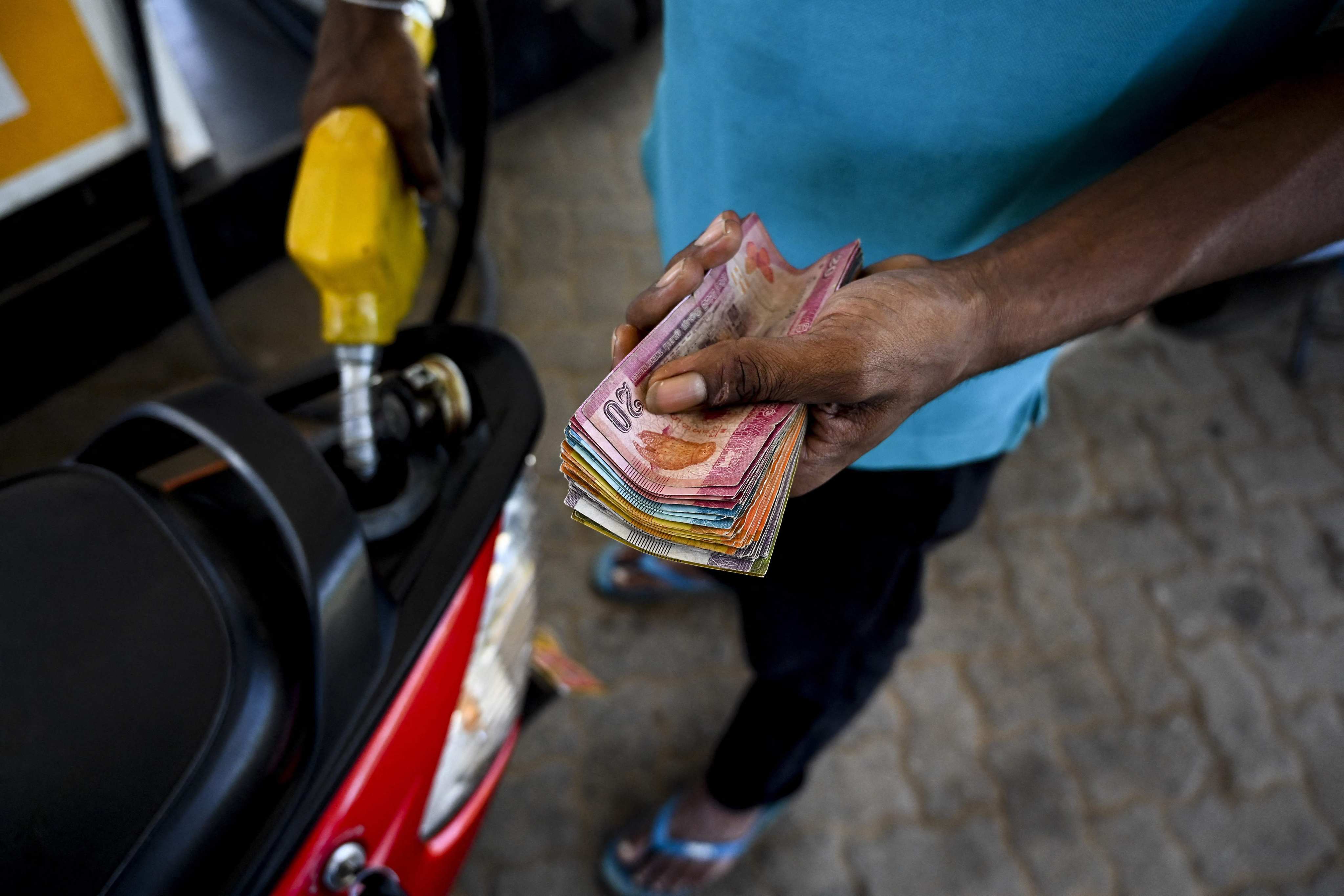 A worker fills the tank of a scooter at a petrol station in Sri Lanka on Tuesday. Photo: AFP