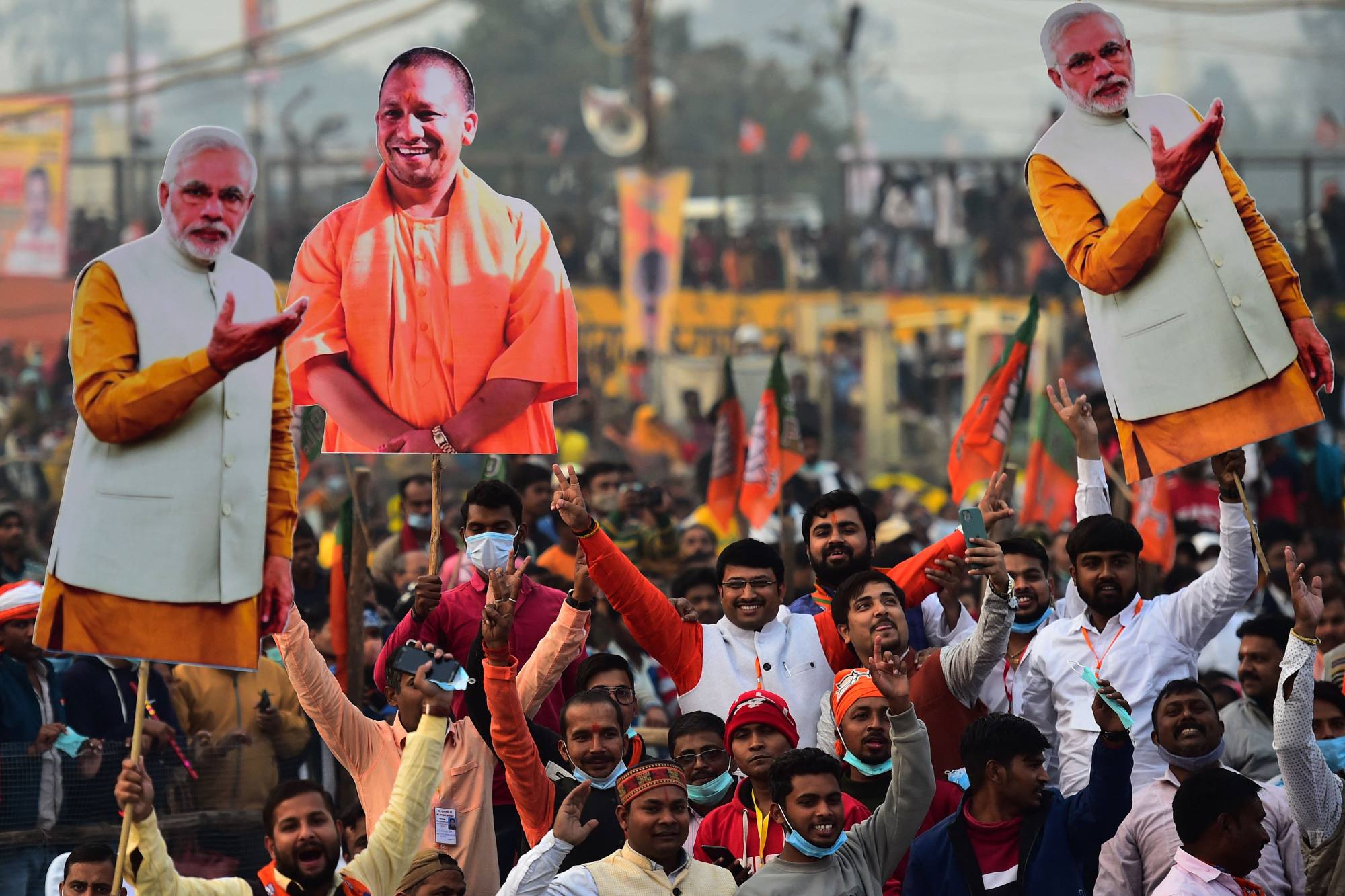 Supporters of the ruling Bharatiya Janata Party hold up signs featuring the image of Narendra Modi. Photo: AFP
