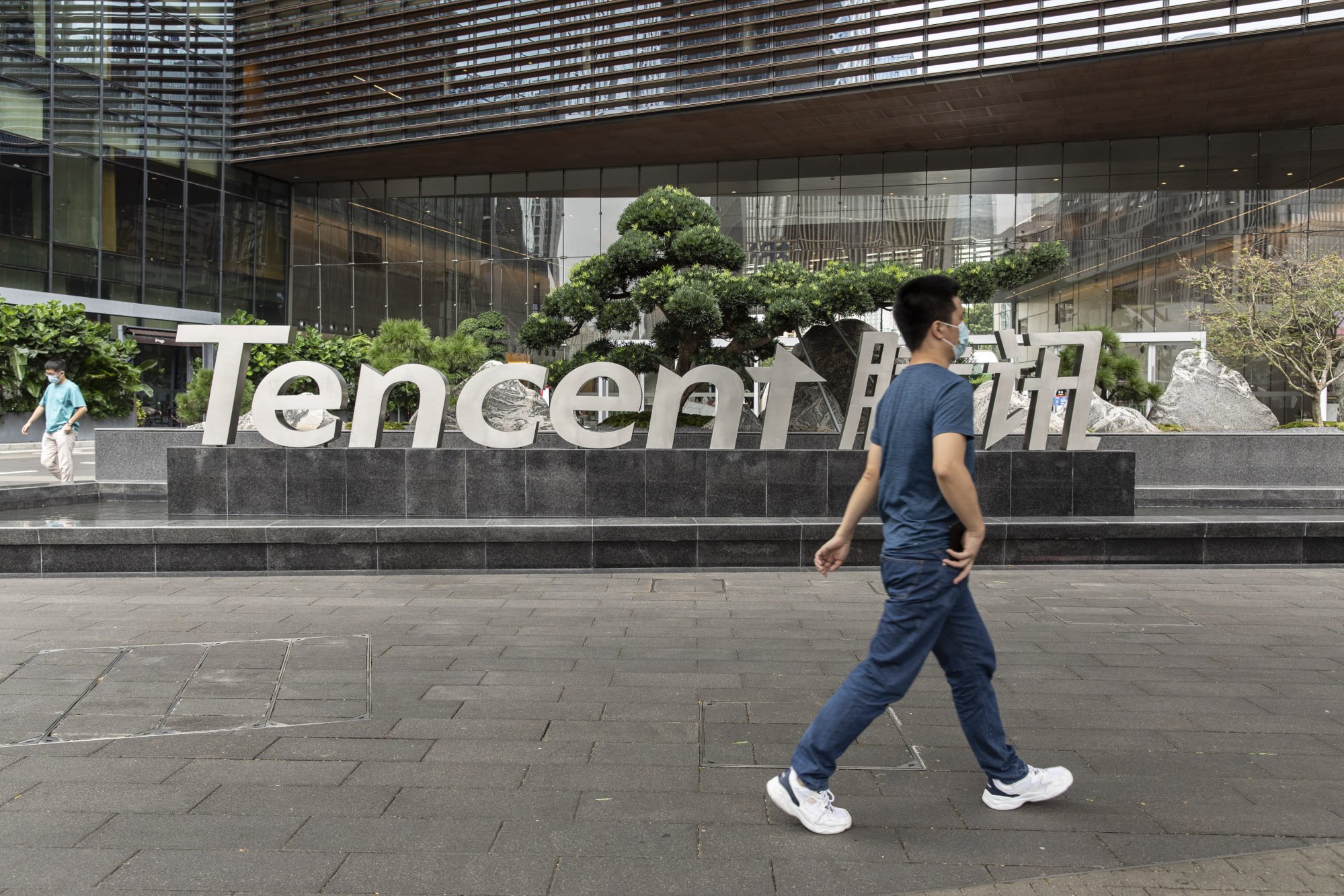 A pedestrian walks near signage for Tencent Holdings at the company’s headquarters in Shenzhen, China, on Oct. 12, 2021. Photo: Bloomberg