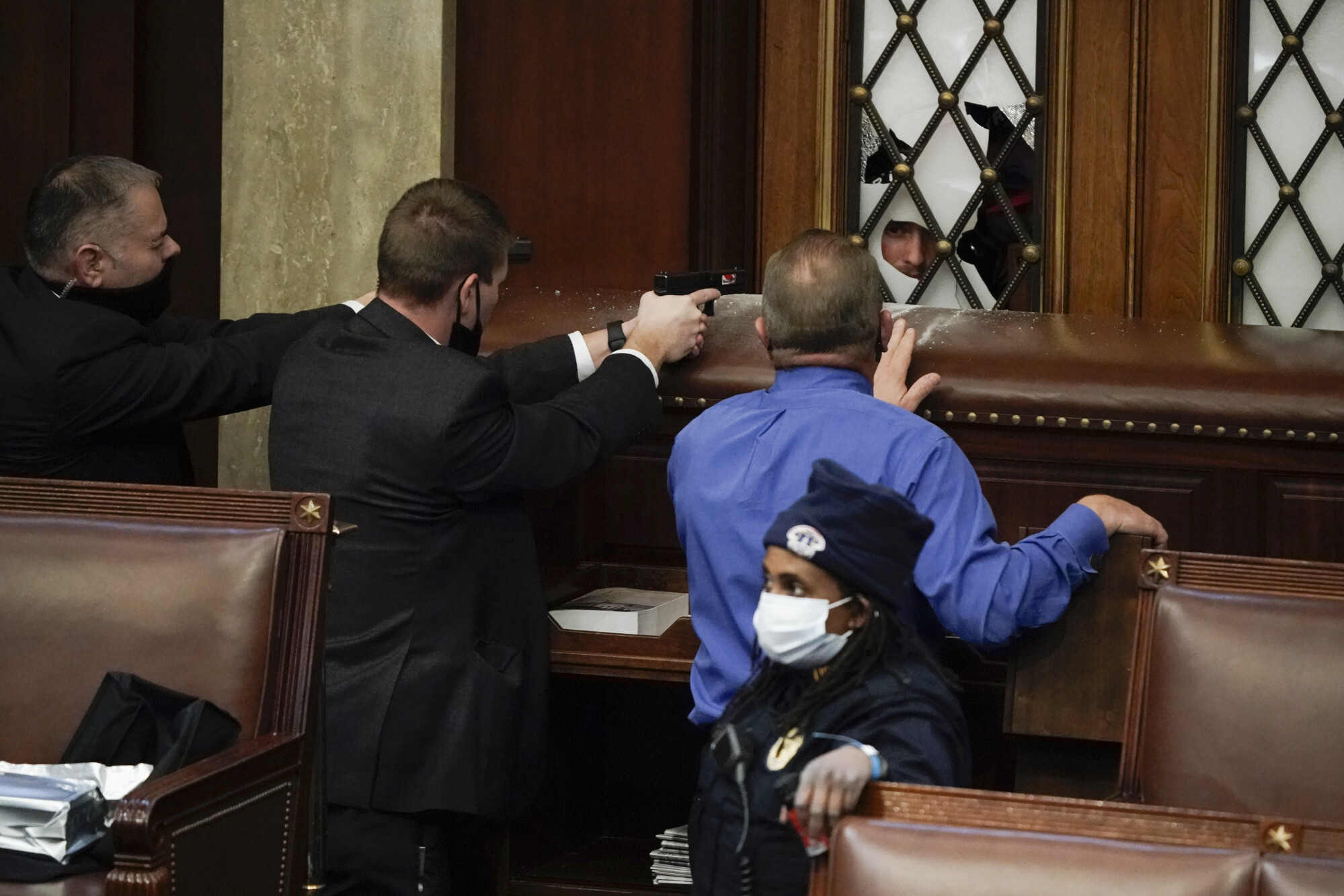 Police officers with guns drawn watch as rioters try to break into the House Chamber at the US Capitol on January 6, 2021. Photo: AP