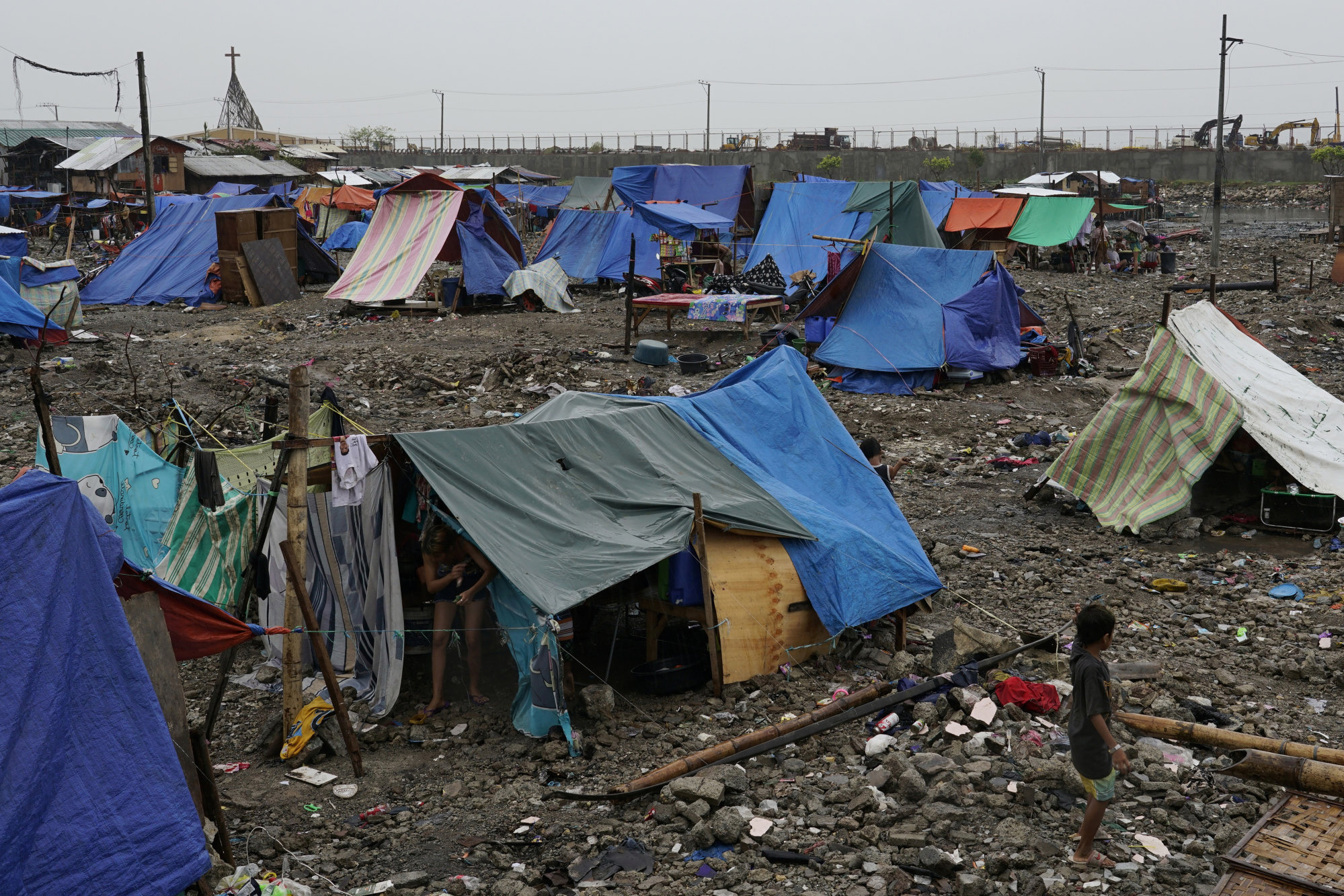 A boy walks past tents of residents who became homeless due to Typhoon Rai in Mambaling, Cebu. Photo: AP