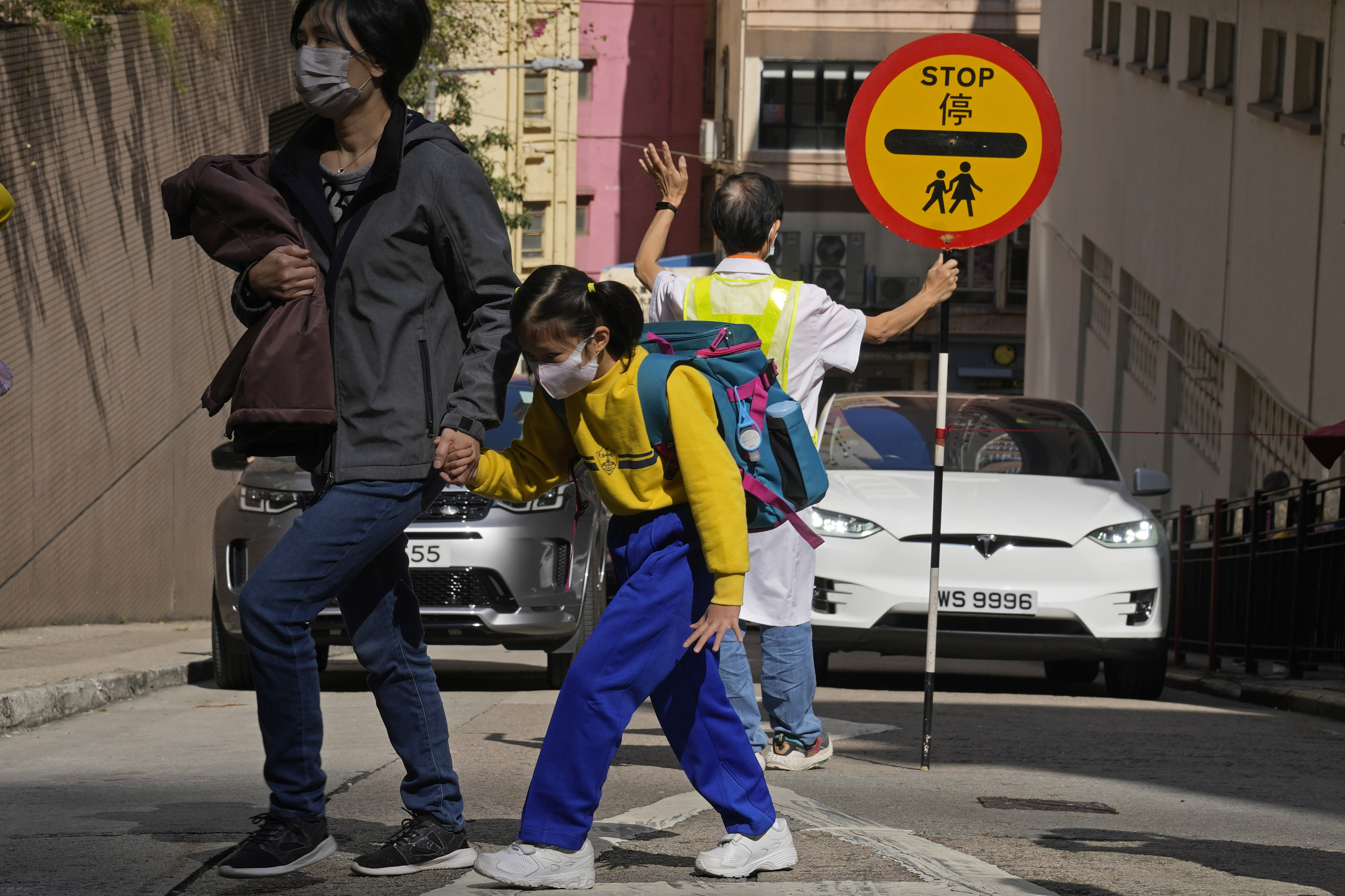 A primary school student walks across a street in Hong Kong on January 11. Young children do not take well to online learning, which demands sustained attention. Photo: AP