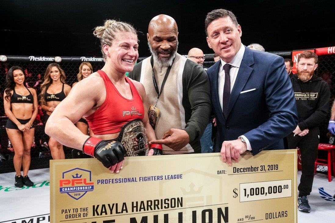 Peter Murray (right) and boxing legend Mike Tyson present 2019 women’s lightweight champion Kayla Harrsion with her US$1 million winner’s cheque. Photo: PFL