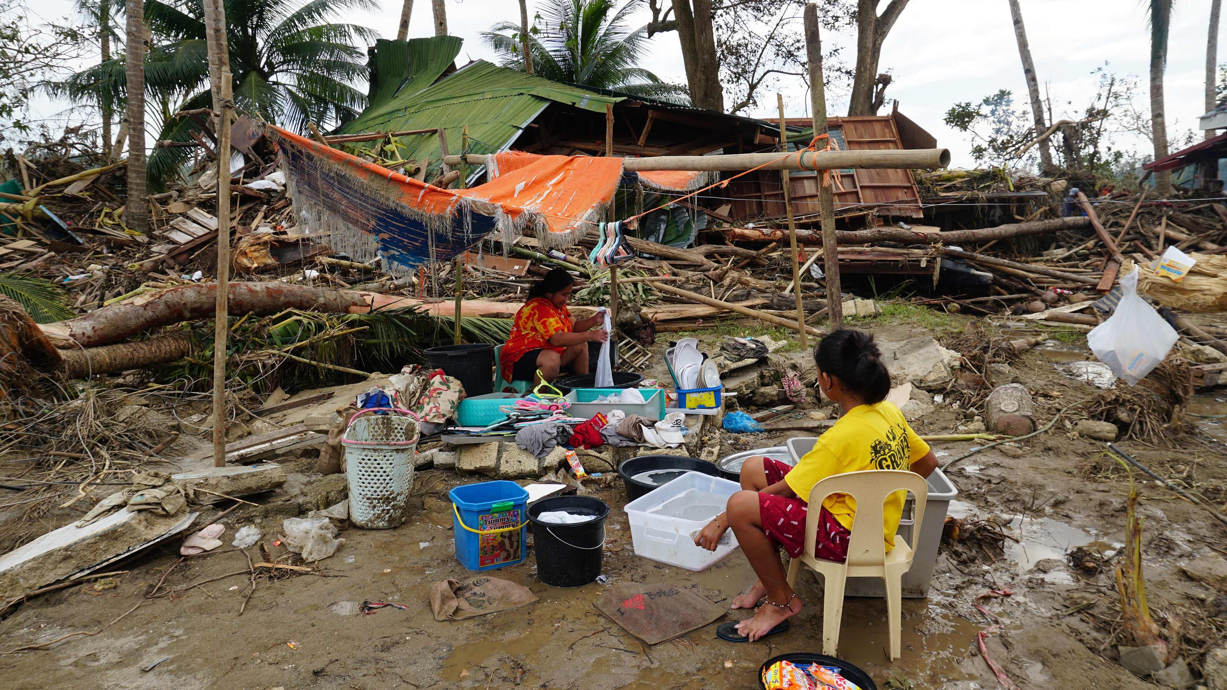 Residents wash their belongings next to their destroyed house in the Philippines’ Bohol province on December 21, 2021, days after super Typhoon Rai caused widespread devastation. Photo: AFP