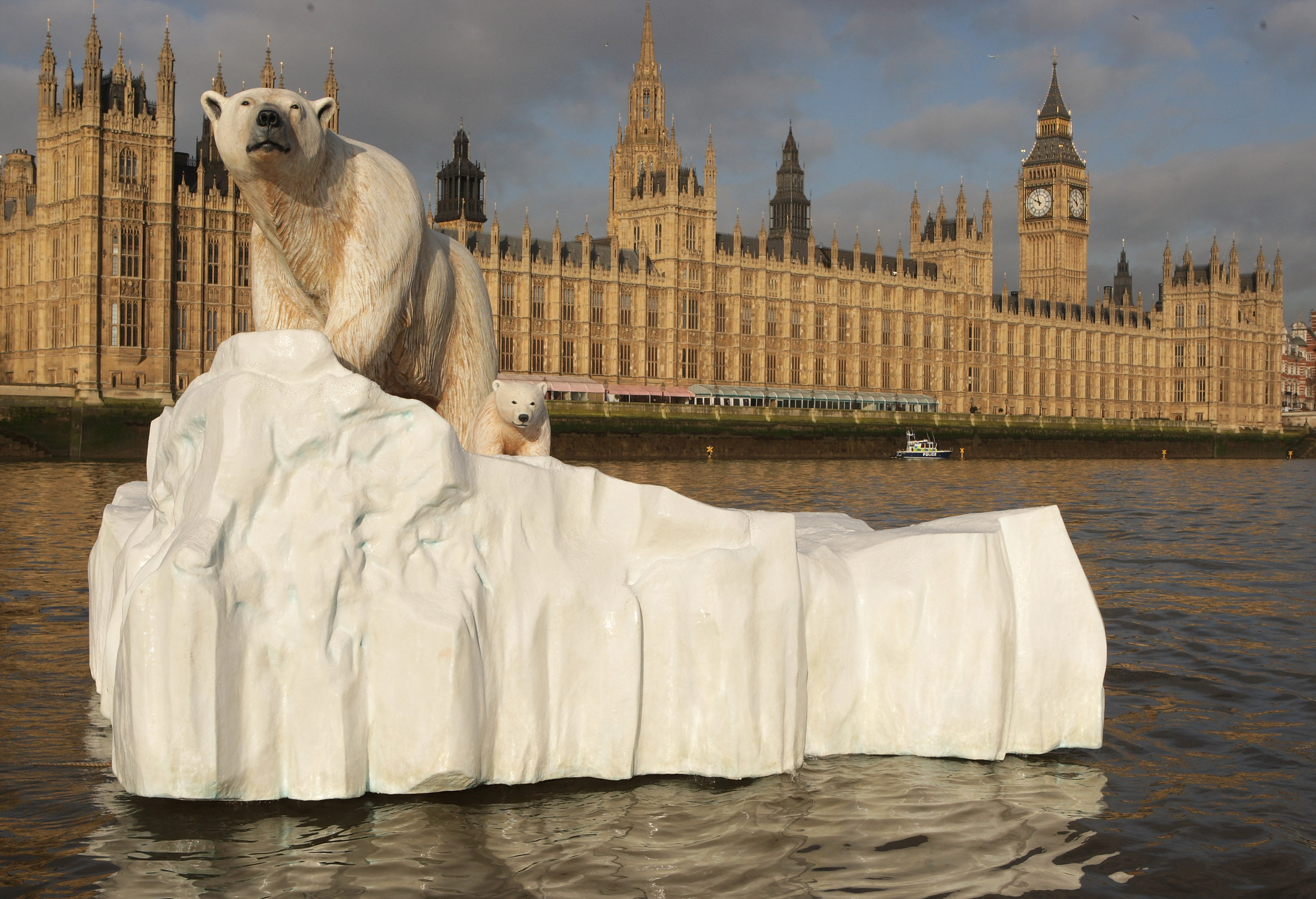 A five-metre (16 ft) high sculpture of a polar bear and cub, afloat on a small iceberg, passes in front of the Houses of Parliament in London to alert lawmakers to the dangers of climate change. Photo: Getty Images