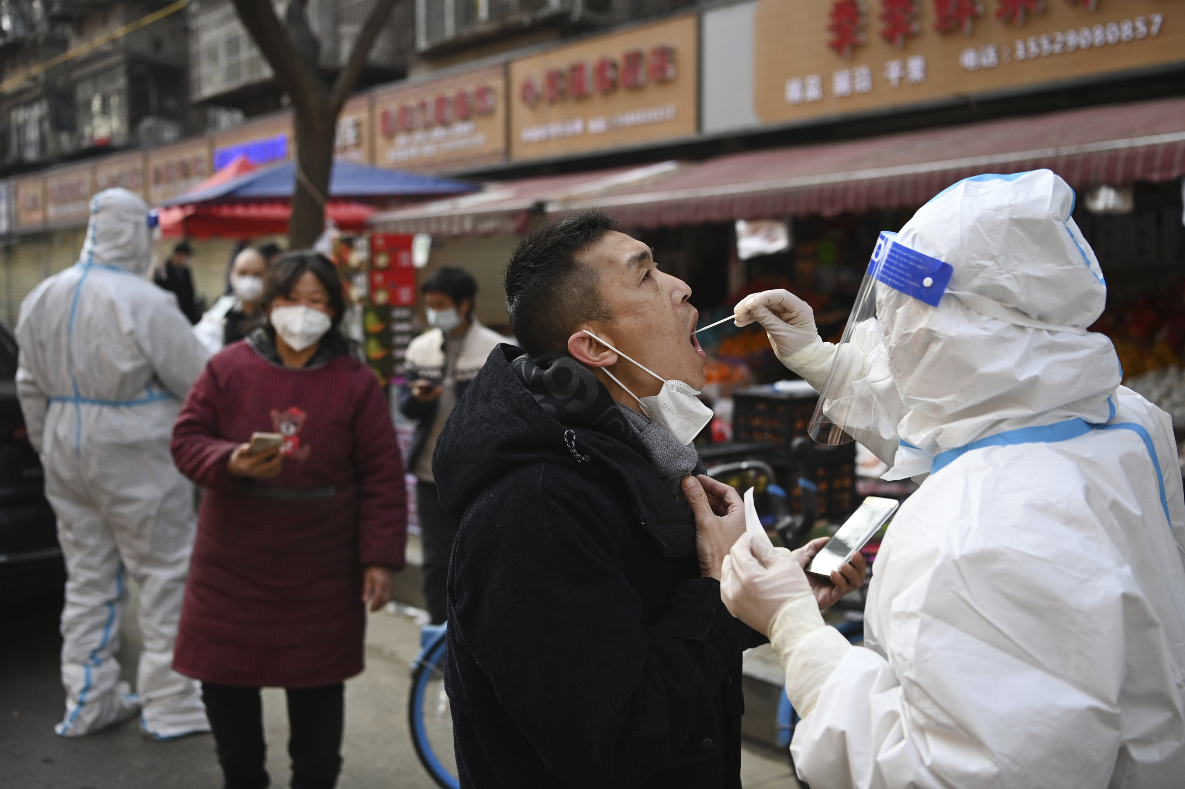 A medical worker collects swab sample from a man at a mobile Covid-19 testing site in Xian. The Chinese city has been under lockdown since late December, making it difficult for some residents to access food and basic supplies. Photo: Xinhua