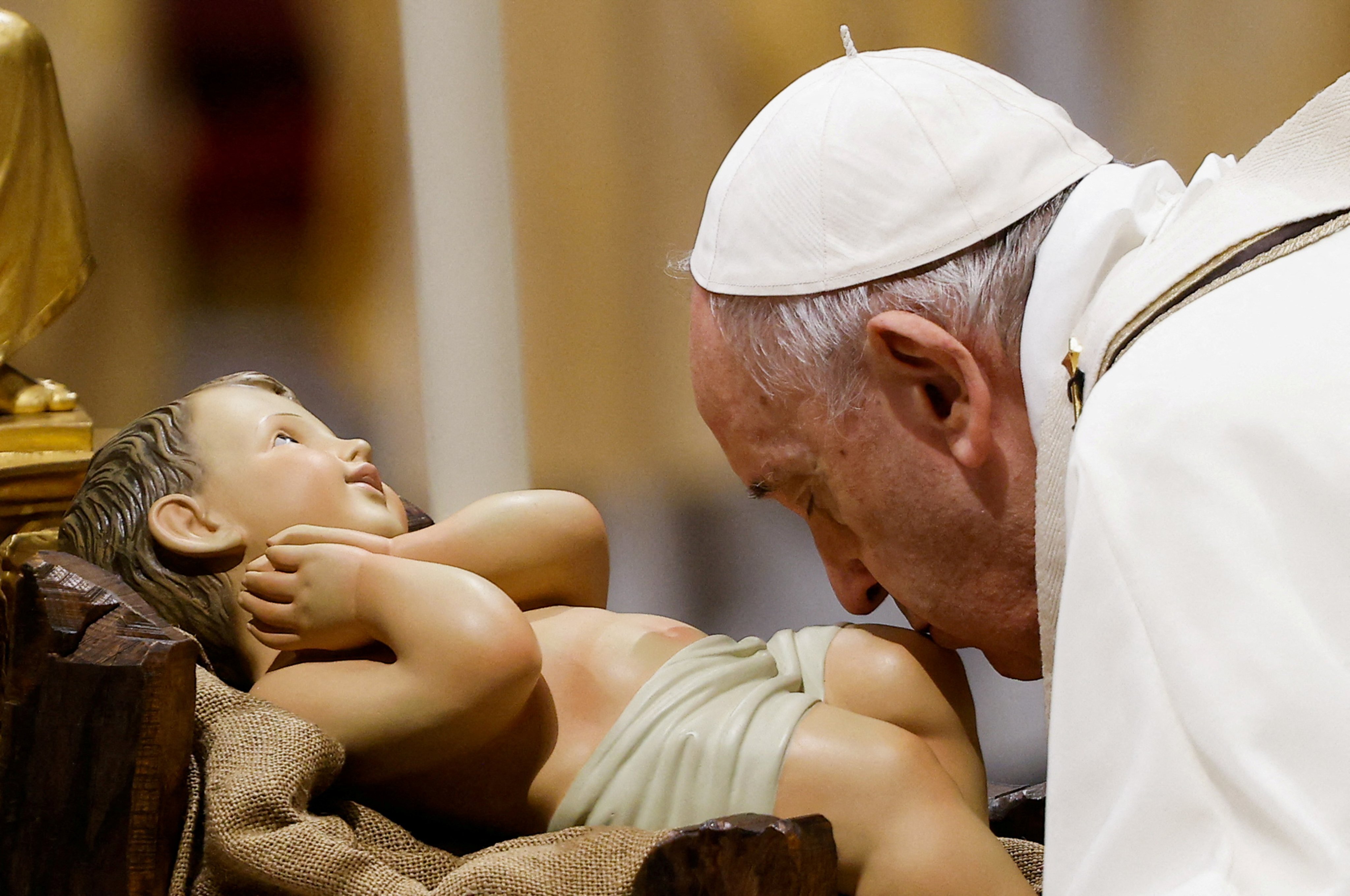 Pope Francis kisses a statue of baby Jesus as he celebrates Christmas Eve Holy Mass in St Peter’s Basilica at the Vatican on December 24, 2021. St Joseph, the earthly father of Jesus, was the subject of one of the Pope’s recent addresses. Photo: Reuters