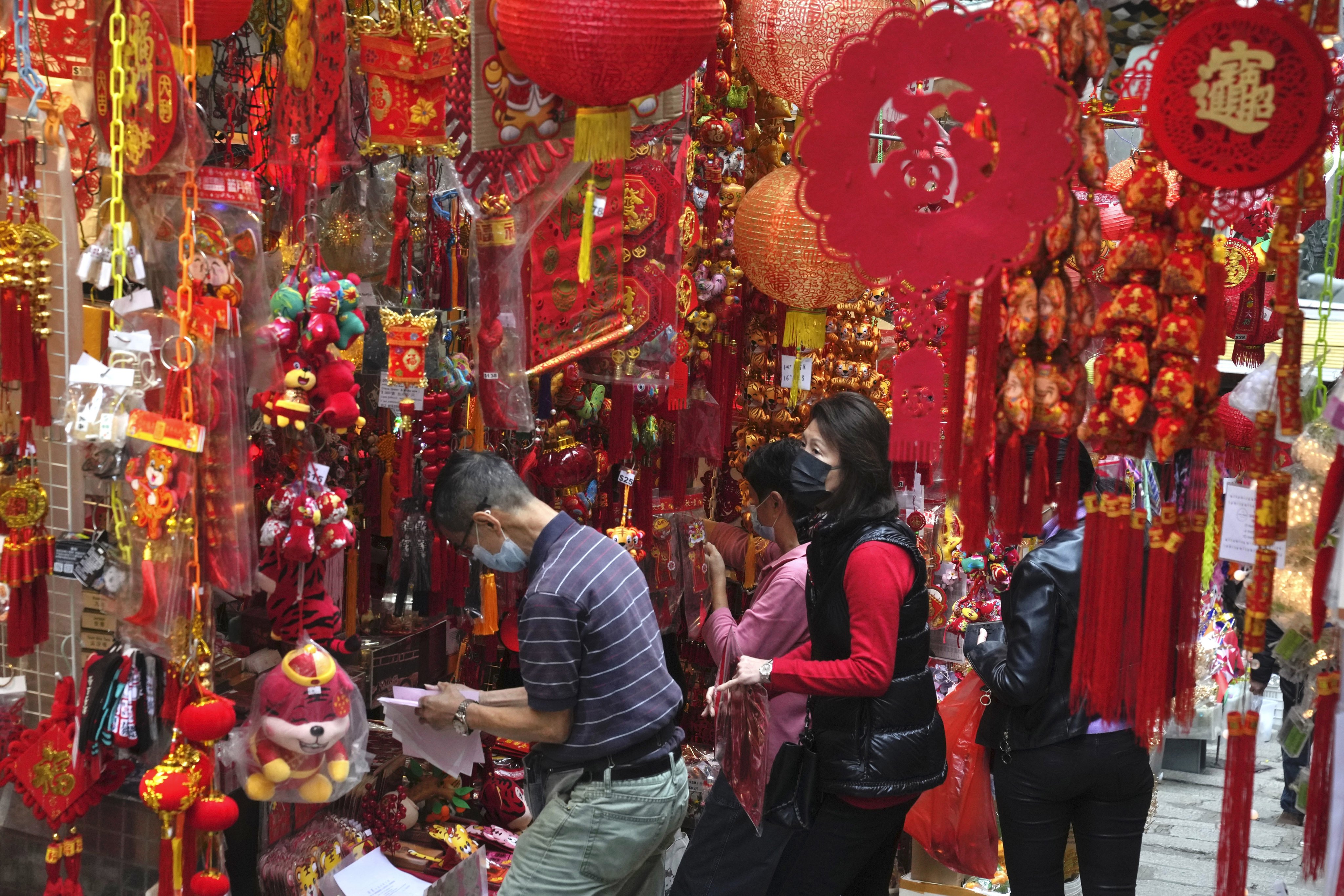 People wearing face masks purchase decorations to celebrate the Lunar New Year in Hong Kong. Photo: AP
