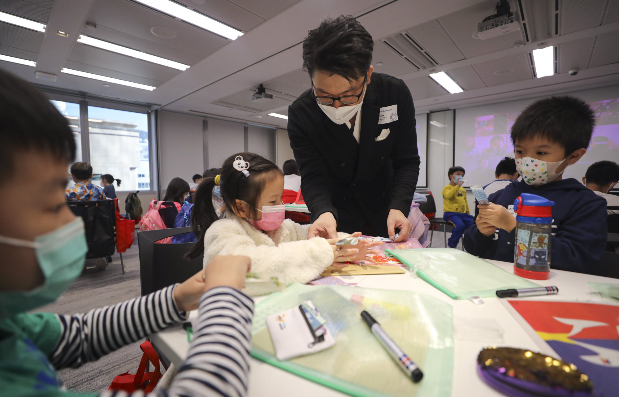 Magician Zenneth Kok teaches children the secrets behind popular magic tricks. Photo: Xiaomei Chen