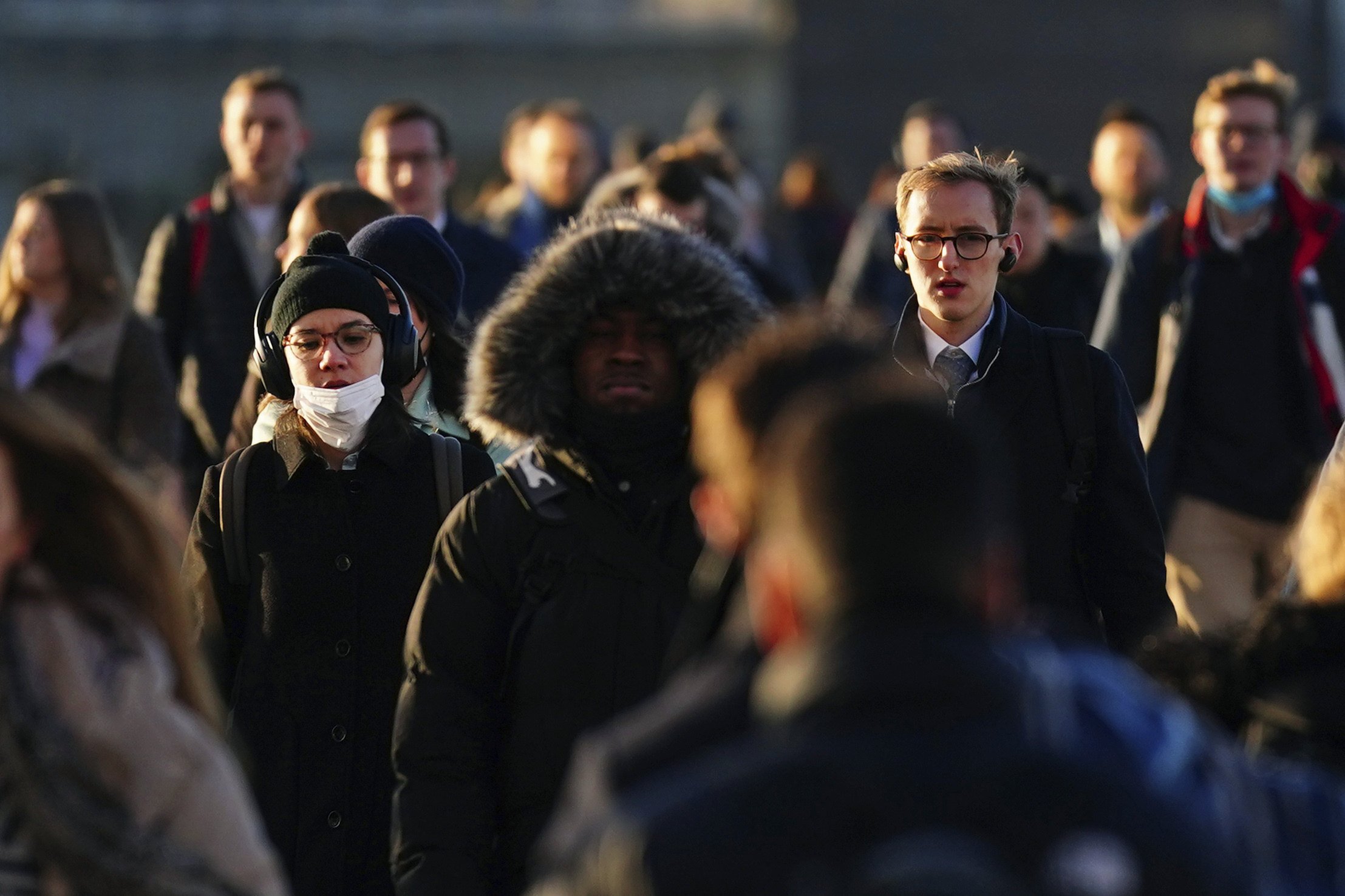 Commuters on London Bridge make their way into offices on January 20, after advice to work from home was dropped by Britain’s Prime Minister Boris Johnson. Photo: PA via AP