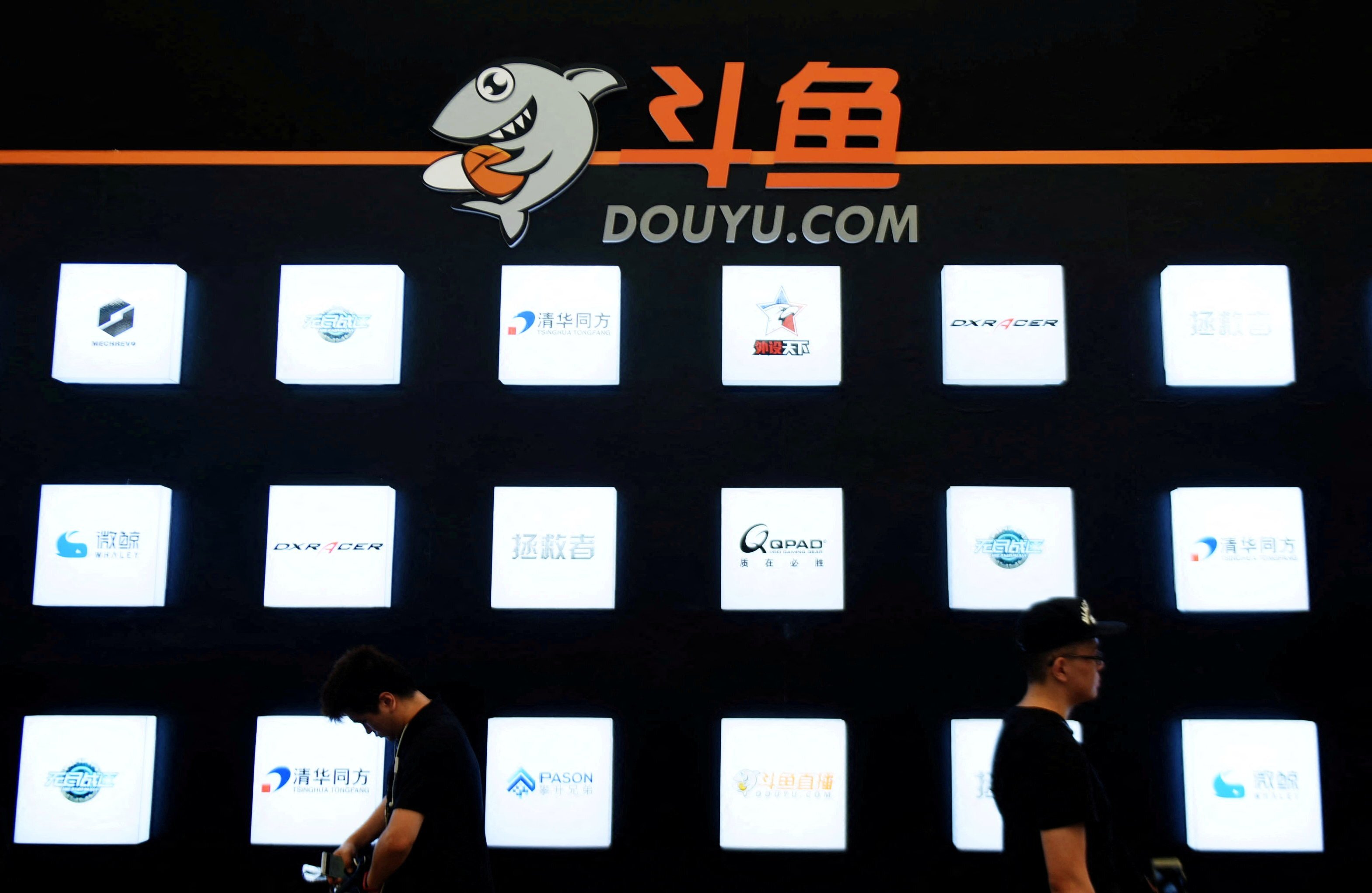 People walk past a booth of live-streaming platform Douyu at the ChinaJoy digital entertainment expo in Shanghai on July 28, 2016. Photo: Reuters