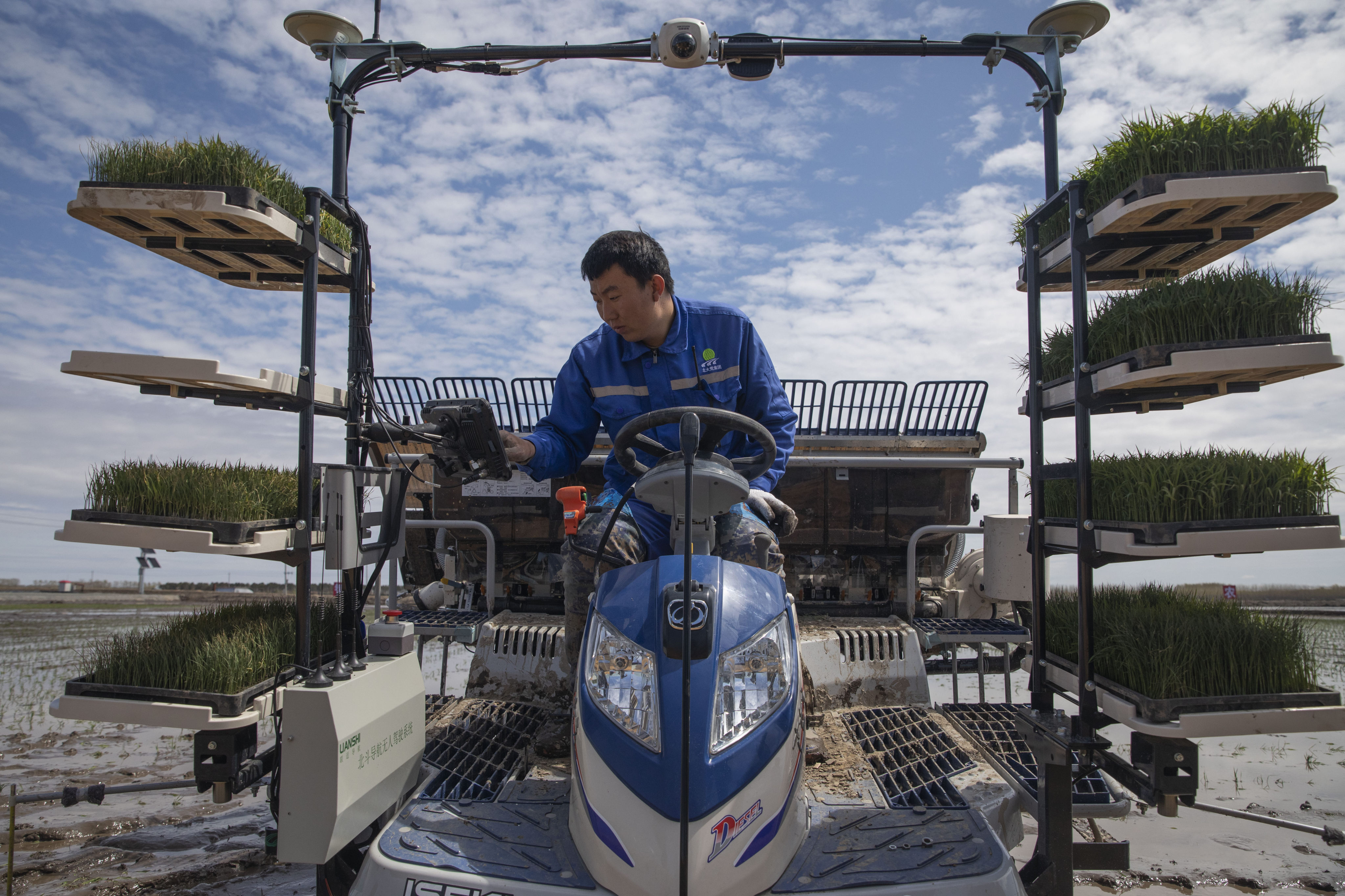 An employee sets the route for an unmanned rice transplanter in a smart agriculture demonstration zone by Hongwei Farm Company of the Beidahuang Group, in northeast China’s Heilongjiang province, on May 11. Photo: Xinhua