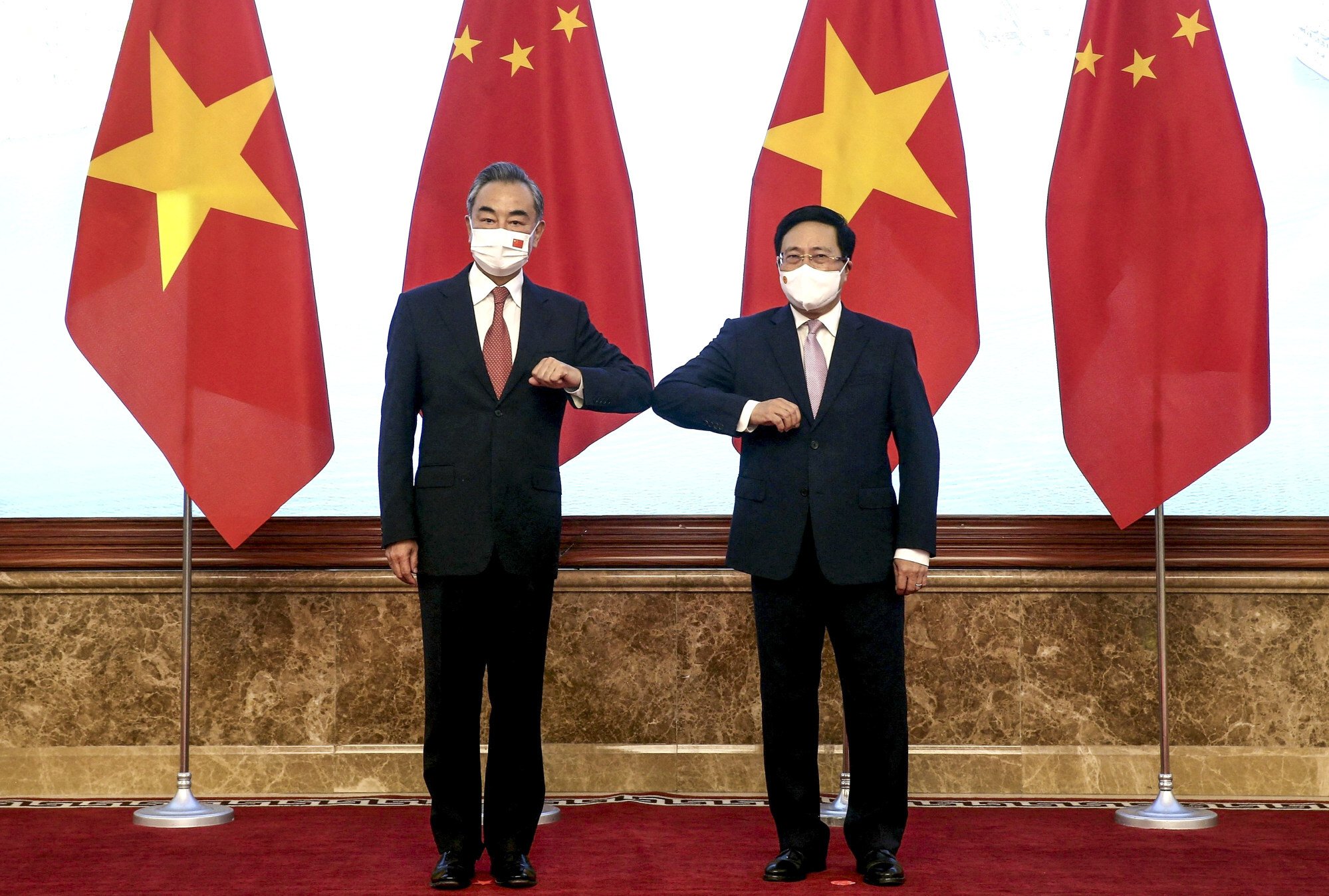 Vietnam’s Deputy Prime Minister Pham Binh Minh (right) greets visiting Chinese Foreign Minister Wang Yi with an elbow bump, ahead of their meeting in Hanoi on September 10 last year. In the span of a year, Wang has visited all 10 Asean countries. Photo: Vietnam News Agency/AFP