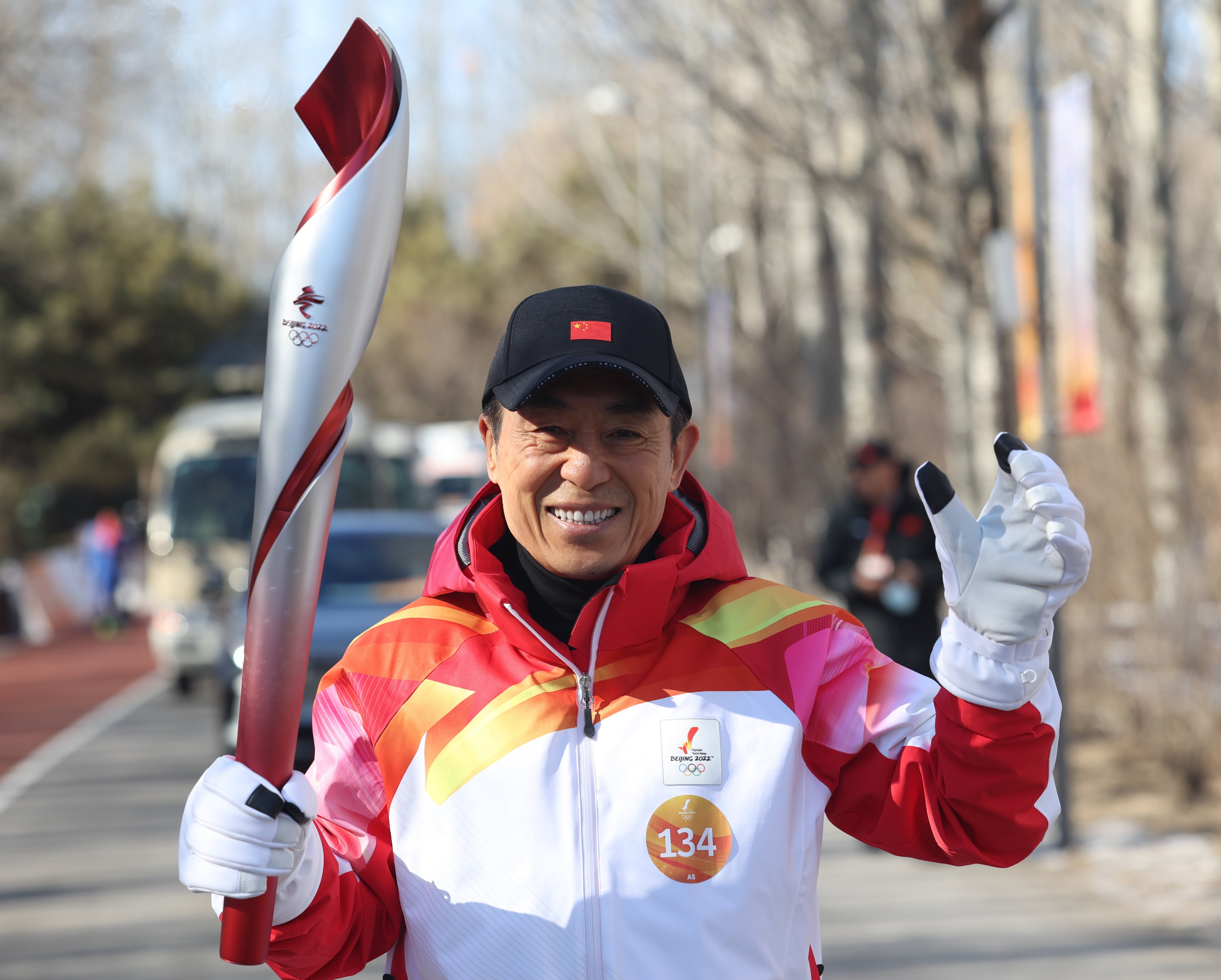 Director Zhang Yimou runs with the Olympic torch in Beijing on Wednesday, the first day of the relay. Photo: Xinhua