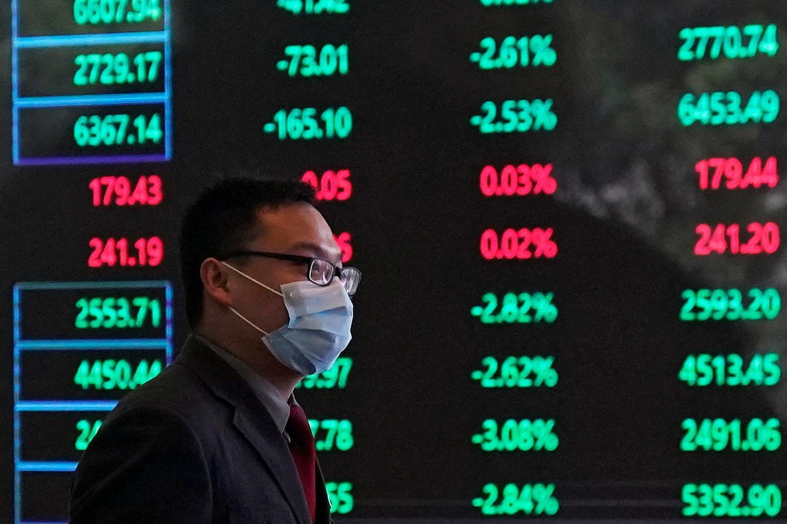 A man walking past an electronic board inside the Shanghai Stock Exchange building in February 2020. Photo: Reuters