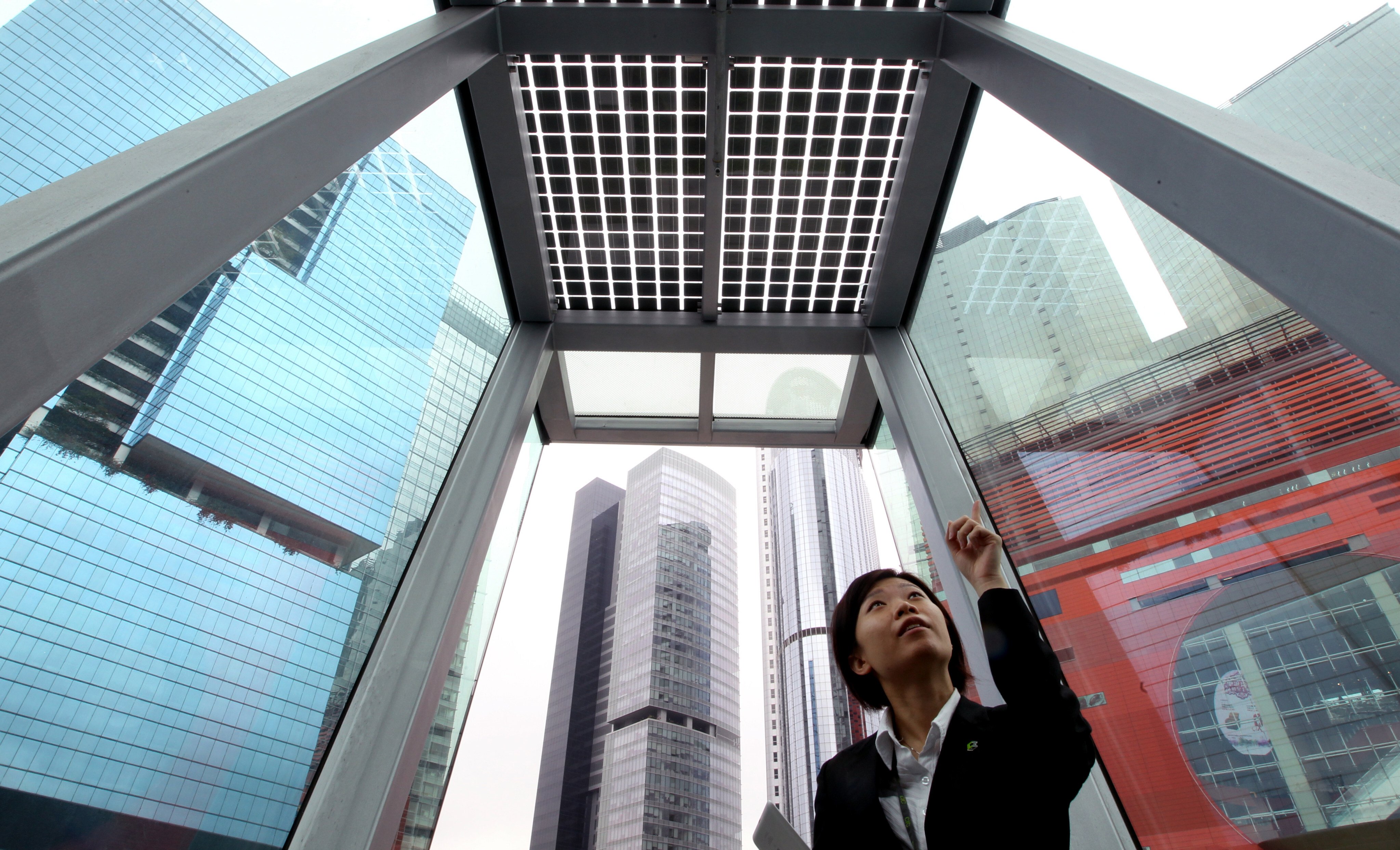 A customer service representative points to a solar panel at Hong Kong’s first zero carbon building, at 8 Sheung Yuet Road in Kowloon Bay, on its first day open to the public on December 17, 2012. Photo: Dickson Lee