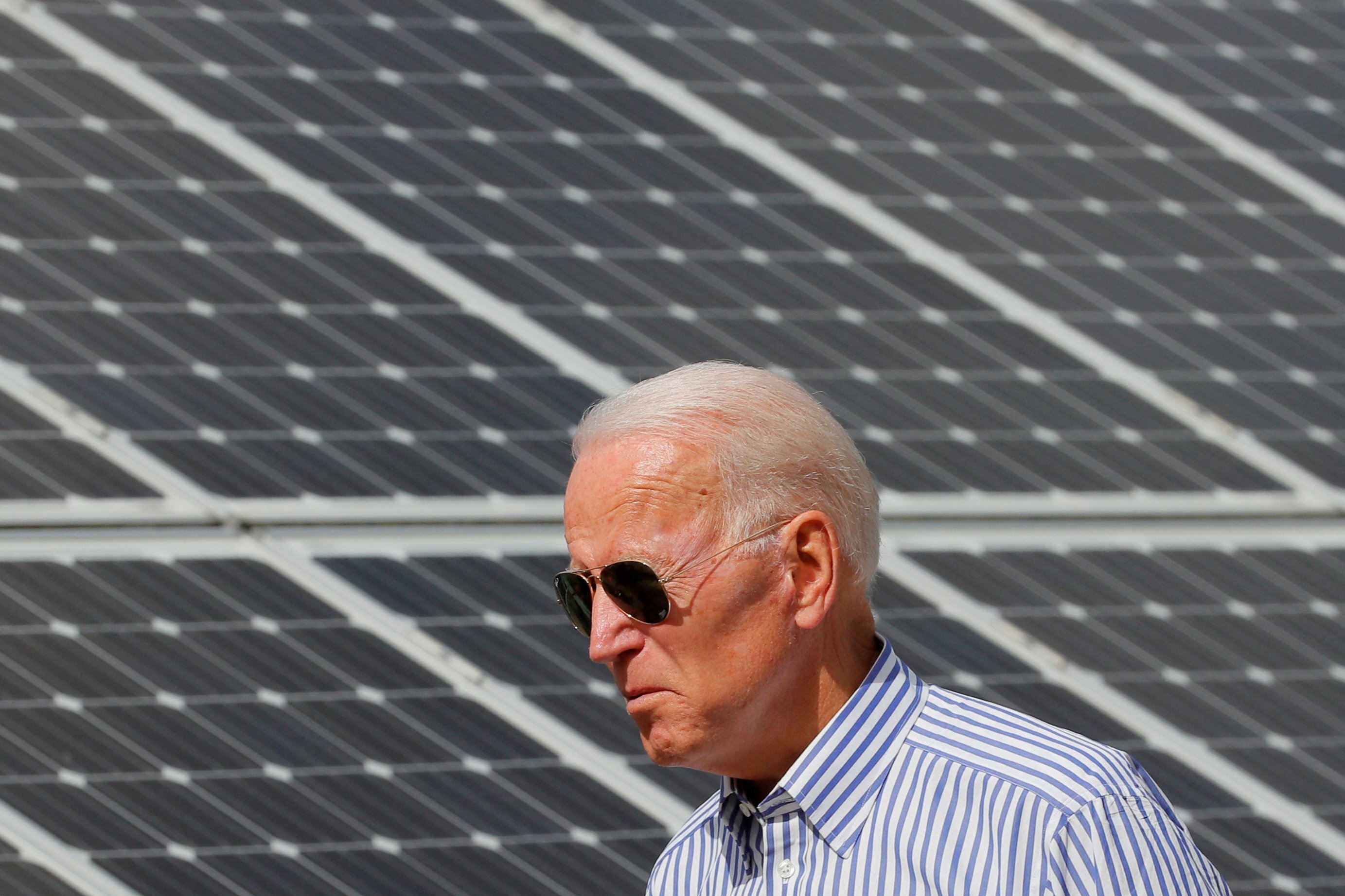 Joe Biden walks past solar panels while touring the Plymouth Area Renewable Energy Initiative in 2019. Biden’s Build Back Better proposal includes a 30 per cent tax credit for solar installation, which will help the US reap the economic benefits of solar power. Photo: Reuters 