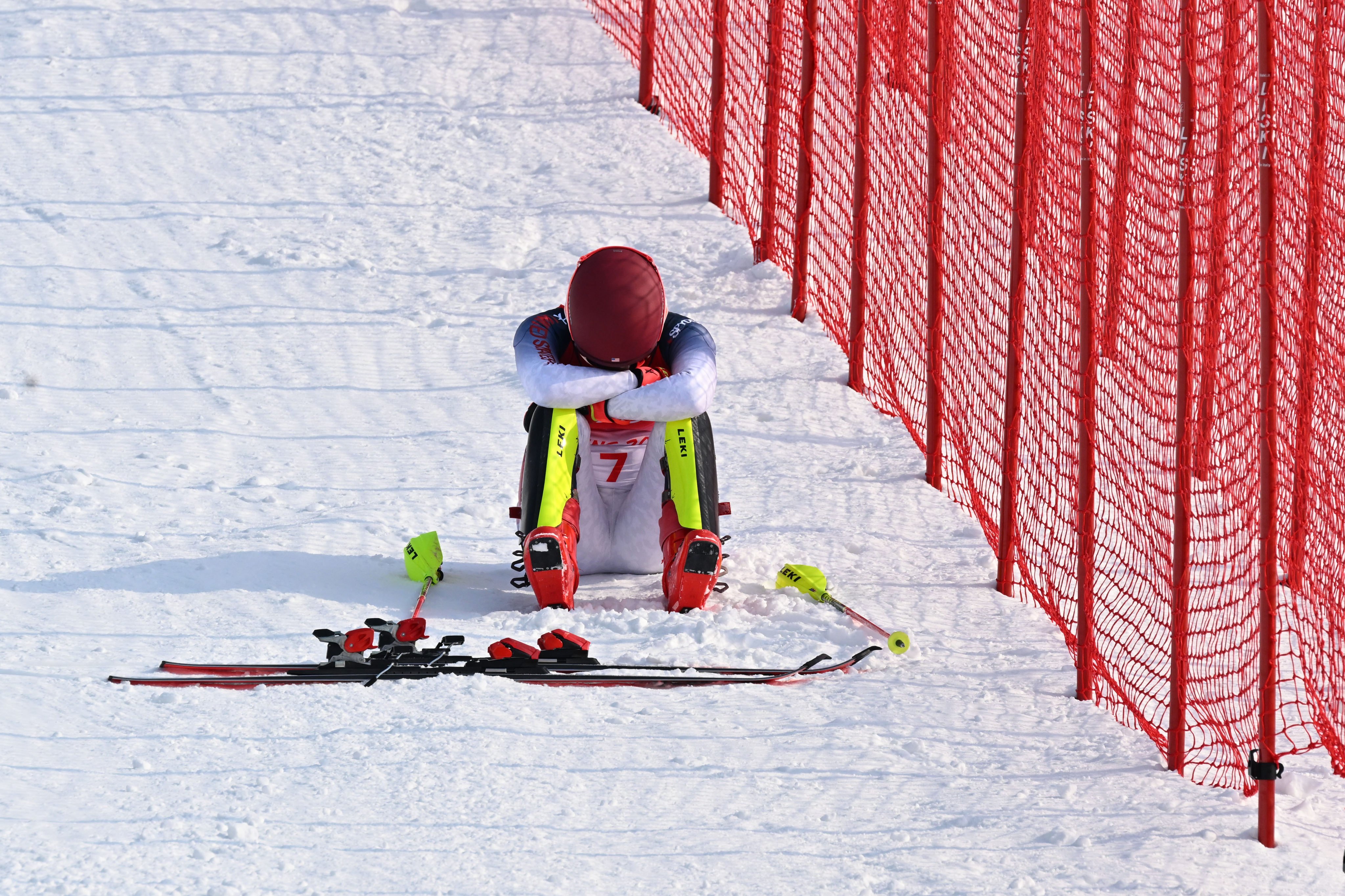 Mikaela Shiffrin sits disconsolately on the side of the course after failing to finish her slalom first run. Photo: Xinhua
