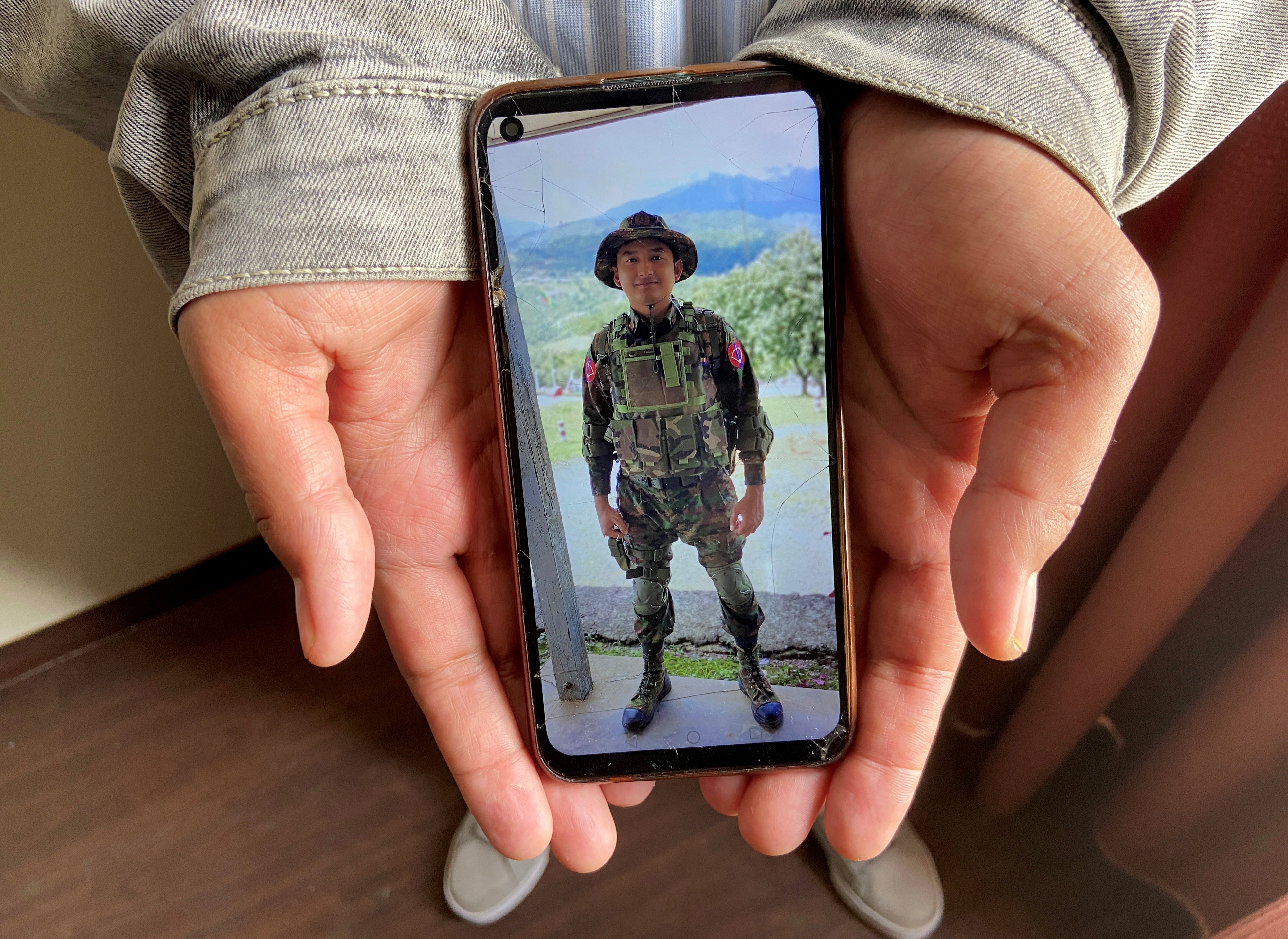 Kaung Thu Win shows a photograph of himself in Myanmar army uniform. Photo: Reuters