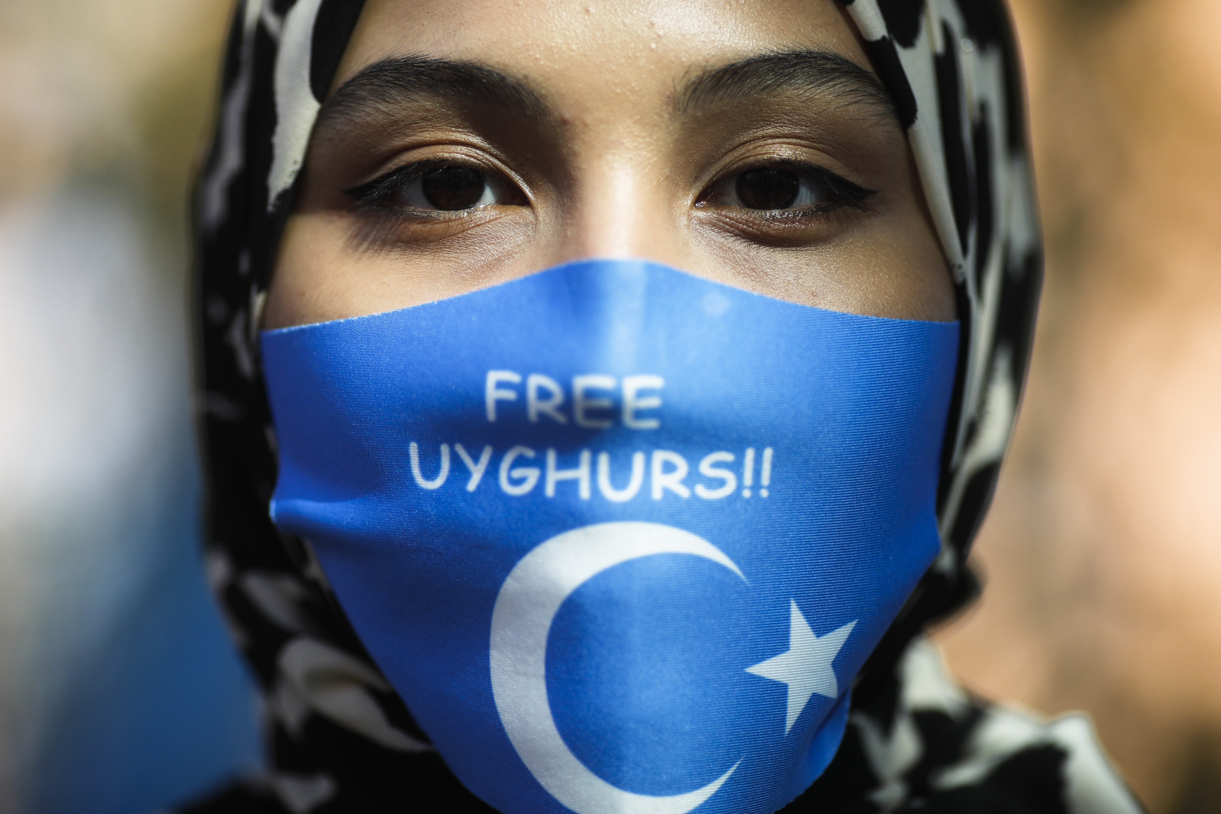 A woman wears a face mask with a slogan supporting Uygurs as she attends a protest in Berlin during a visit by Chinese Foreign Minister Wang Yi in September 2020. Photo: AP