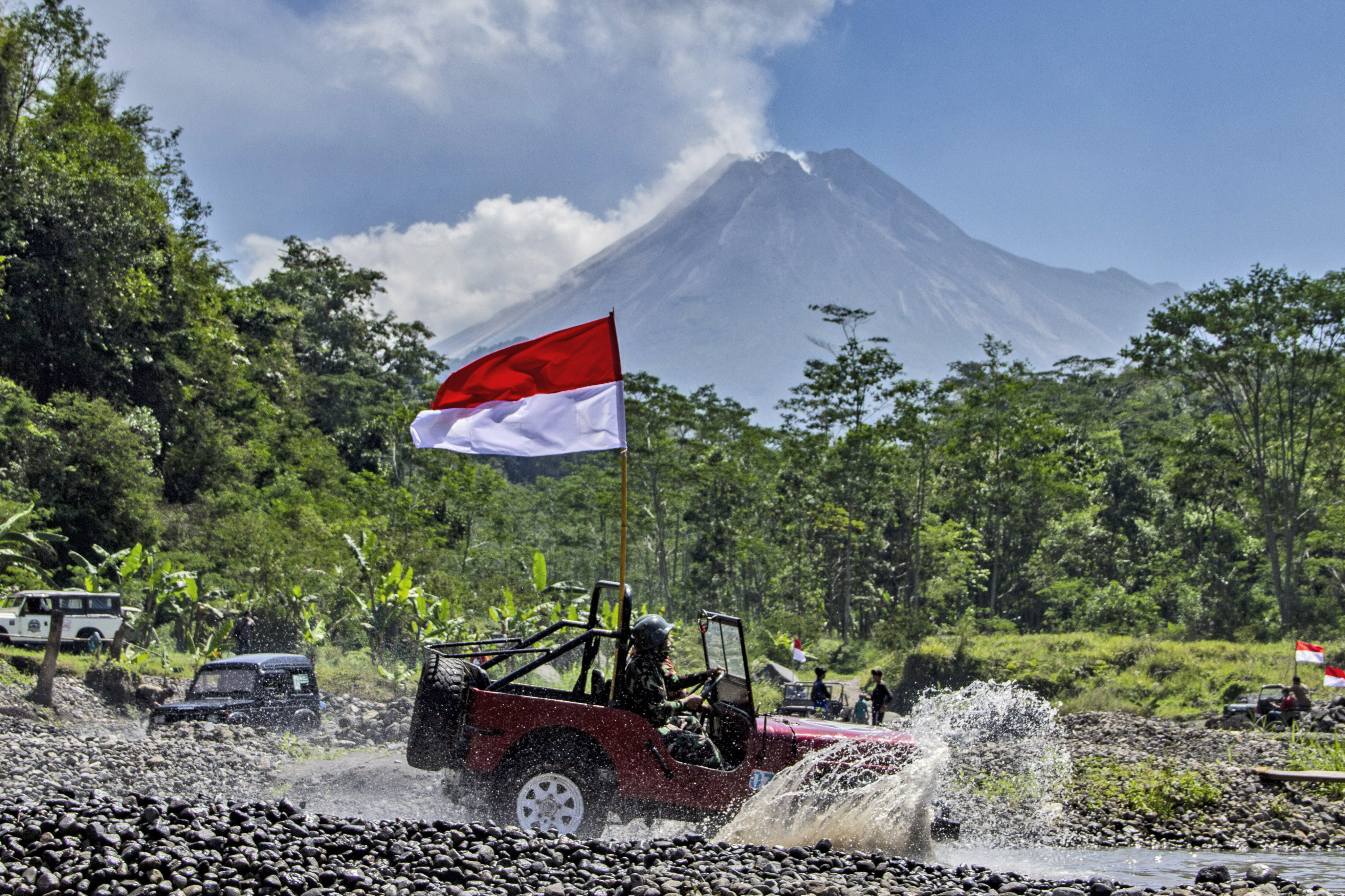 The Indonesian national flag waves from a car with Mount Merapi as the backdrop. Photo: AP 