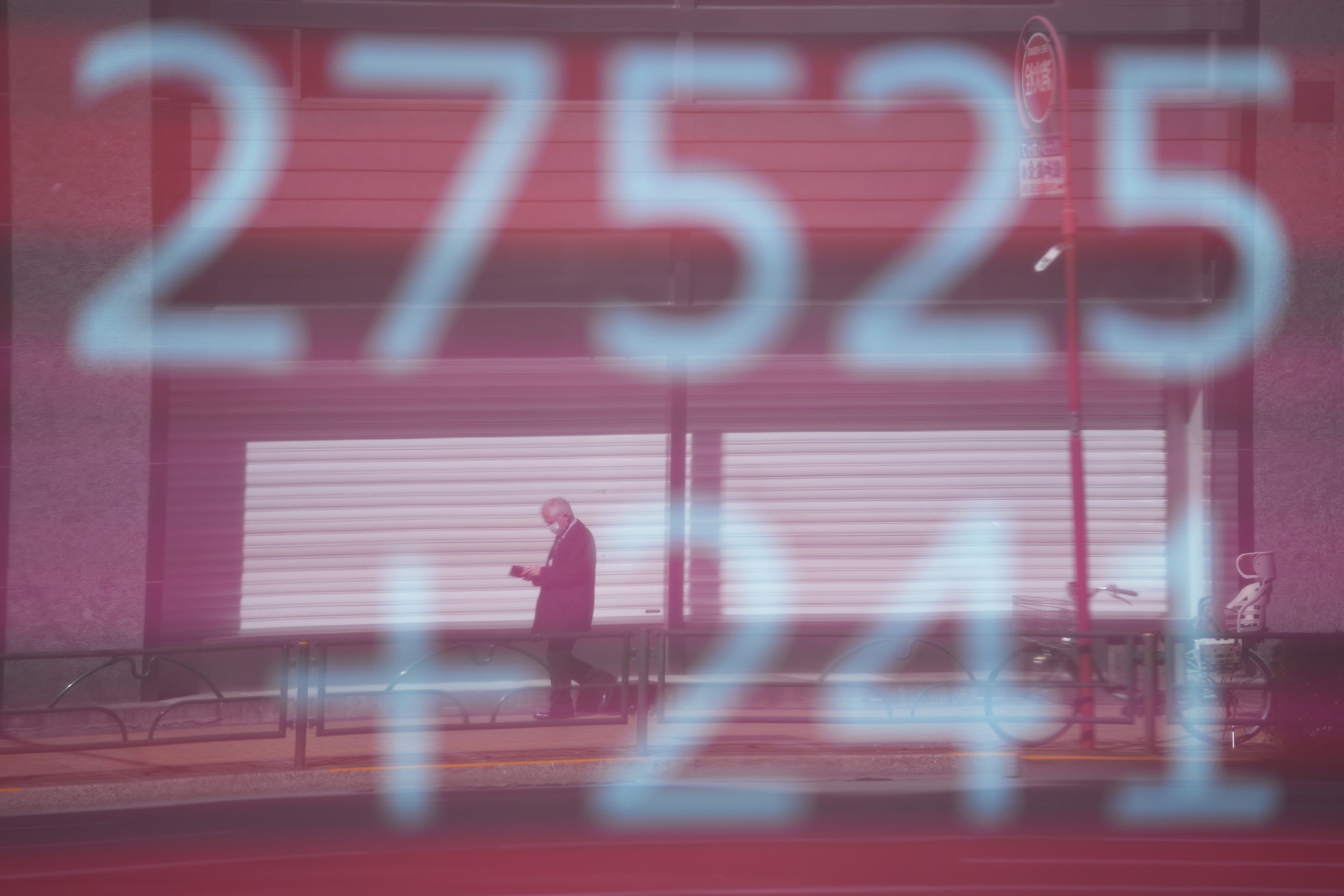 A man is reflected on a monitor showing Japan’s Nikkei 225 index at a securities firm in Tokyo on February 9. Rising inflation and the coming interest rate hikes are of concern to investors everywhere. Photo: AP 