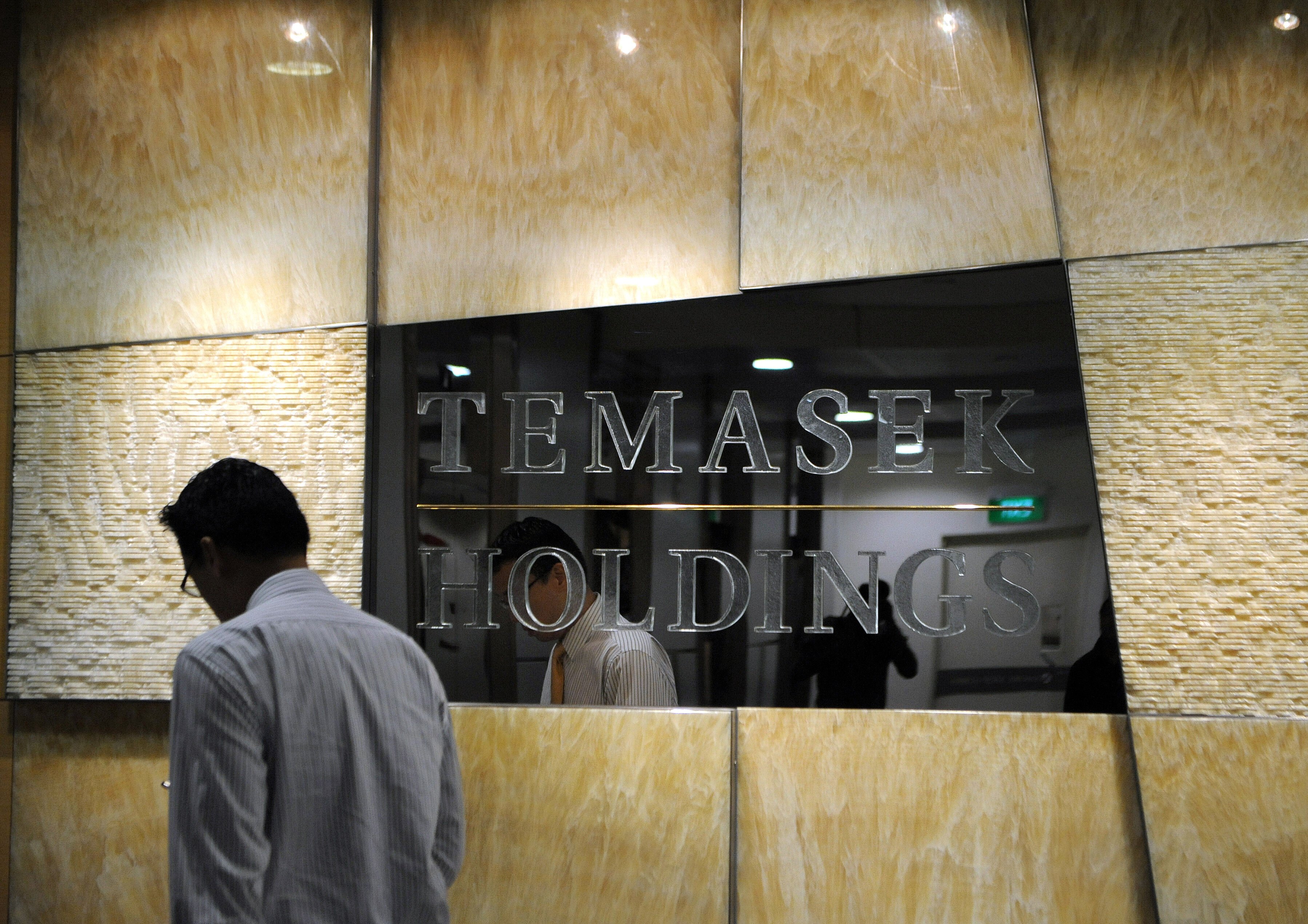 A man walks past a company logo for Temasek Holdings in Singapore. File photo: AFP