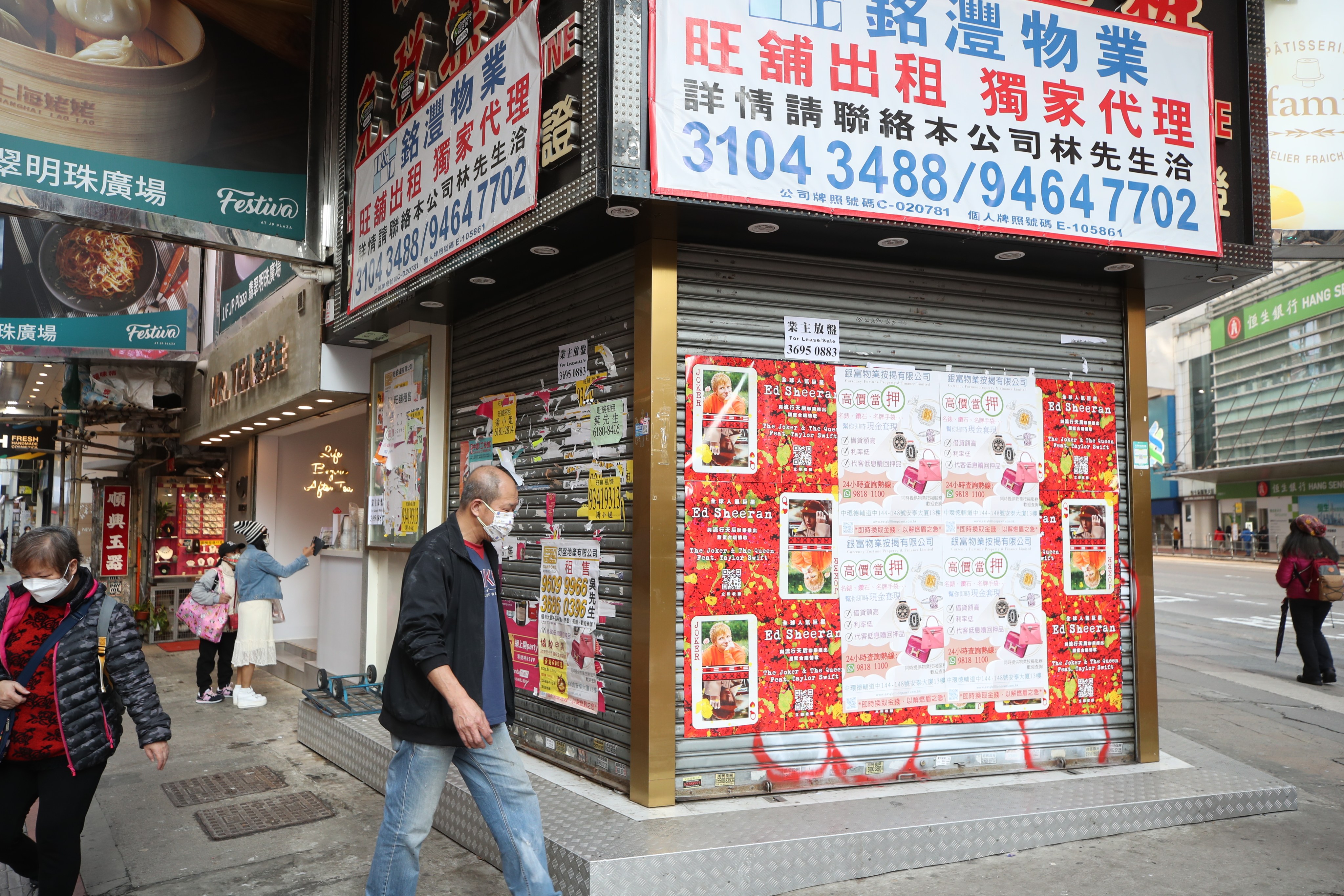Residents walk past a closed retail shop in Causeway Bay. Photo: Edmond So