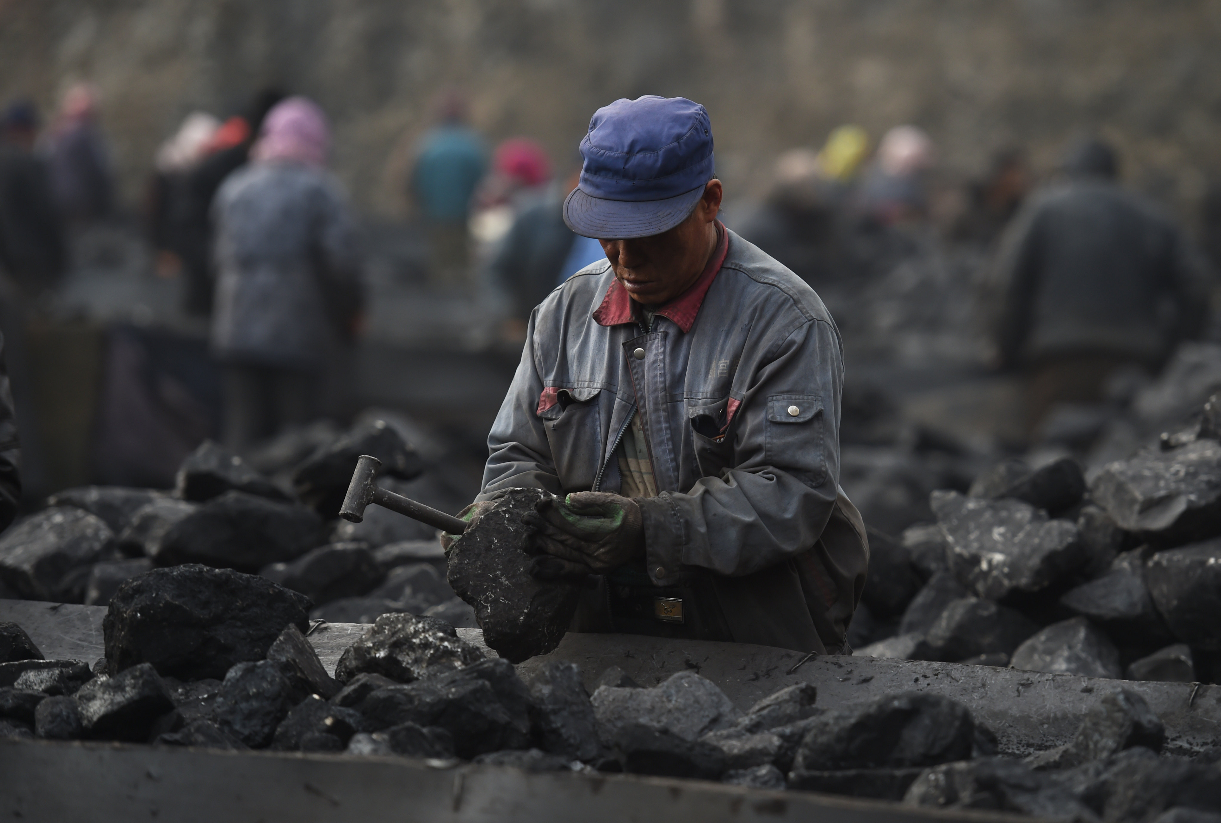 A worker sorting coal on a conveyer belt, near a coal mine at Datong, in northern China’s Shanxi province on November 25, 2015. Photo: AFP