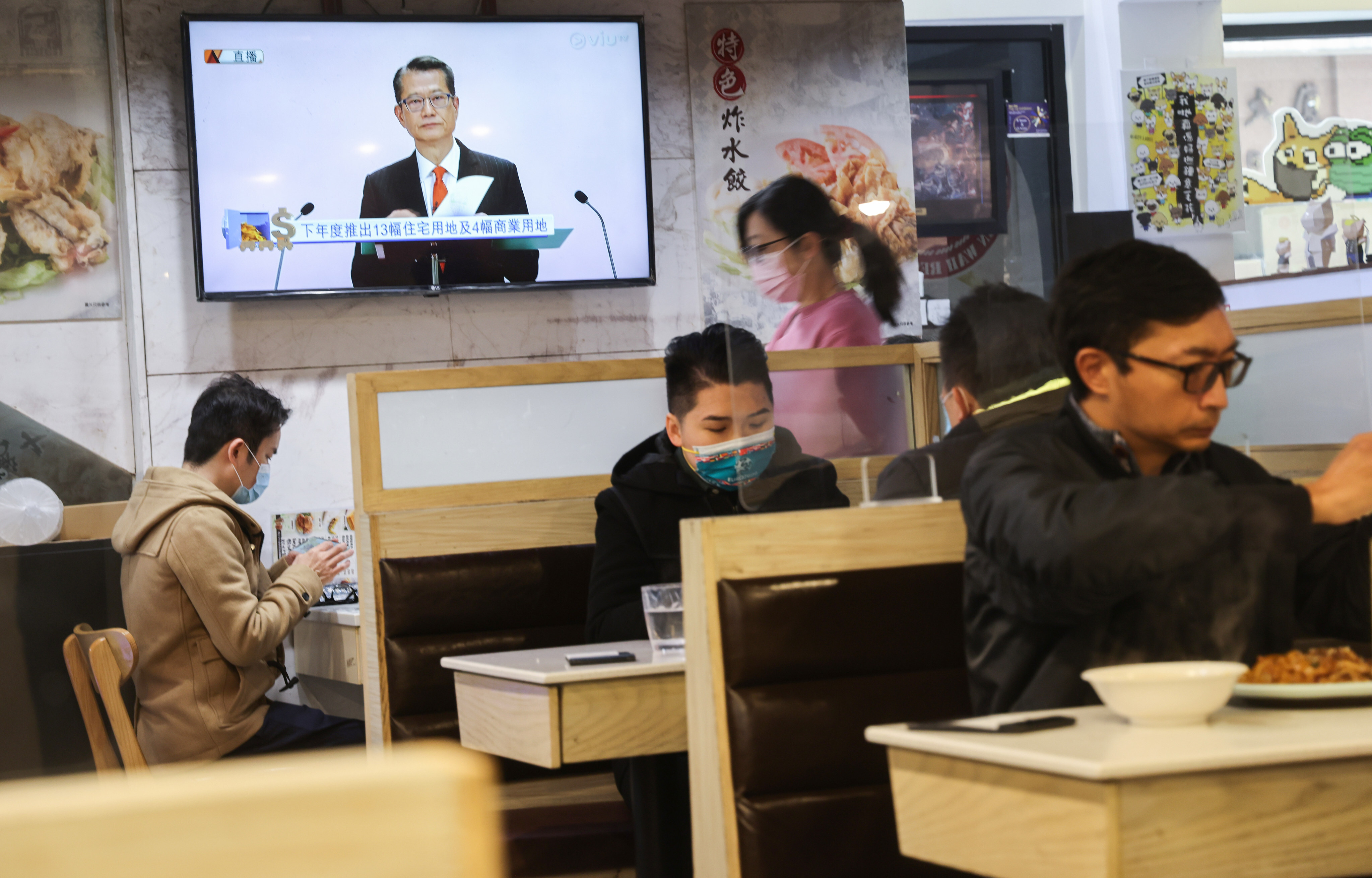 Financial Secretary Paul Chan is seen on a TV screen in a restaurant in Wan Chai delivering his budget on Wednesday. Photo: May Tse