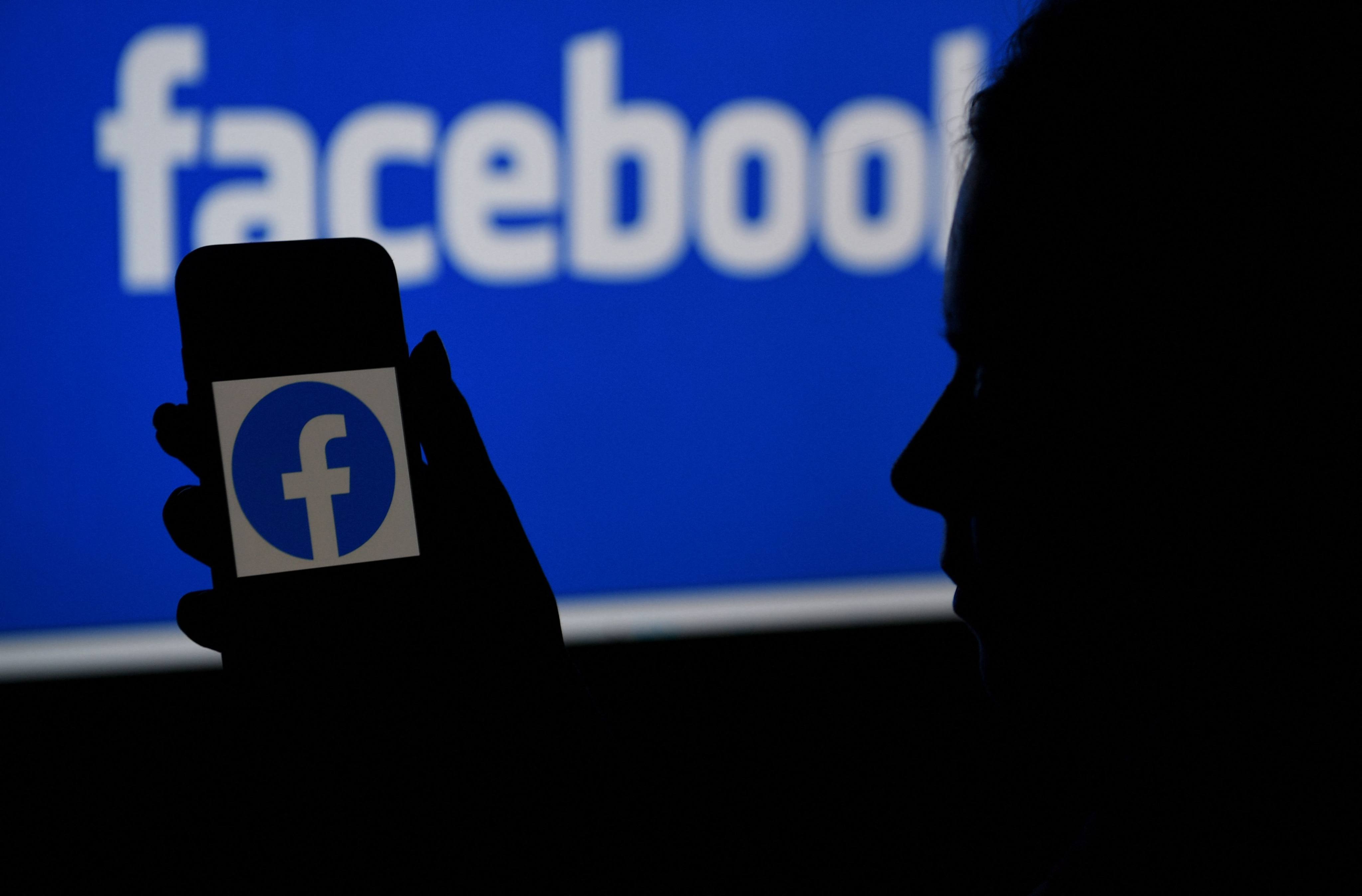 In this file illustration photo taken on April 7, 2021, a smart phone screen displays the logo of Facebook on a Facebook website background. Photo: AFP
