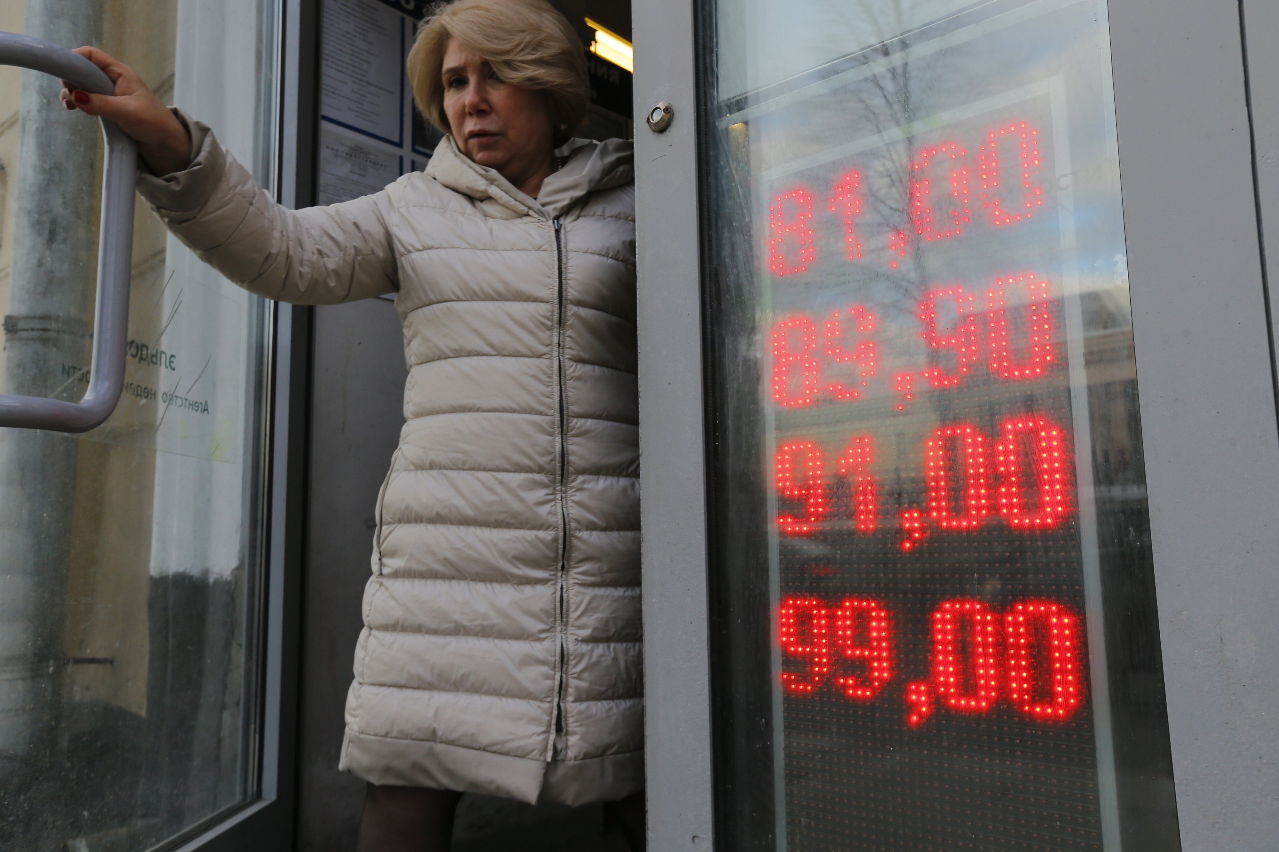 A woman leaves an exchange office showing the exchange rates of the US dollar and euro to roubles on February 24. The sanctions imposed on Russia and the resulting crash of the rouble have the Kremlin scrambling to keep the country’s economy running. Photo: AP