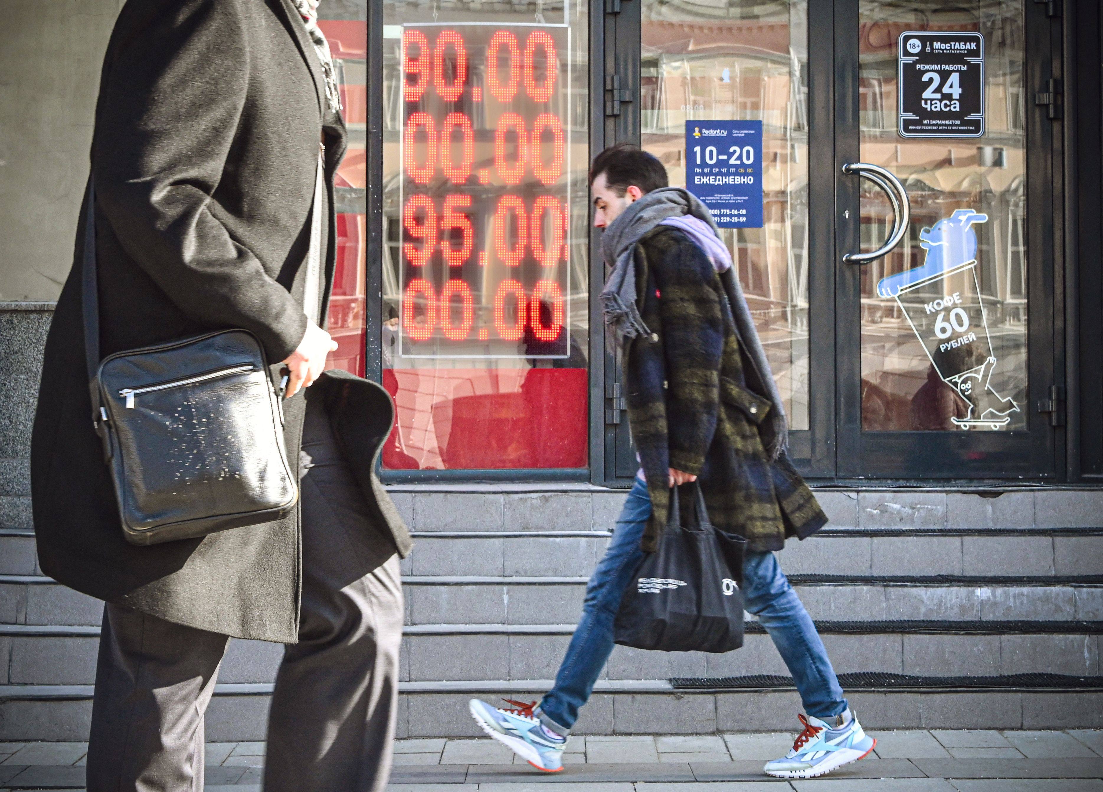 People walk past a currency exchange office in central Moscow on February 28. Photo: AFP