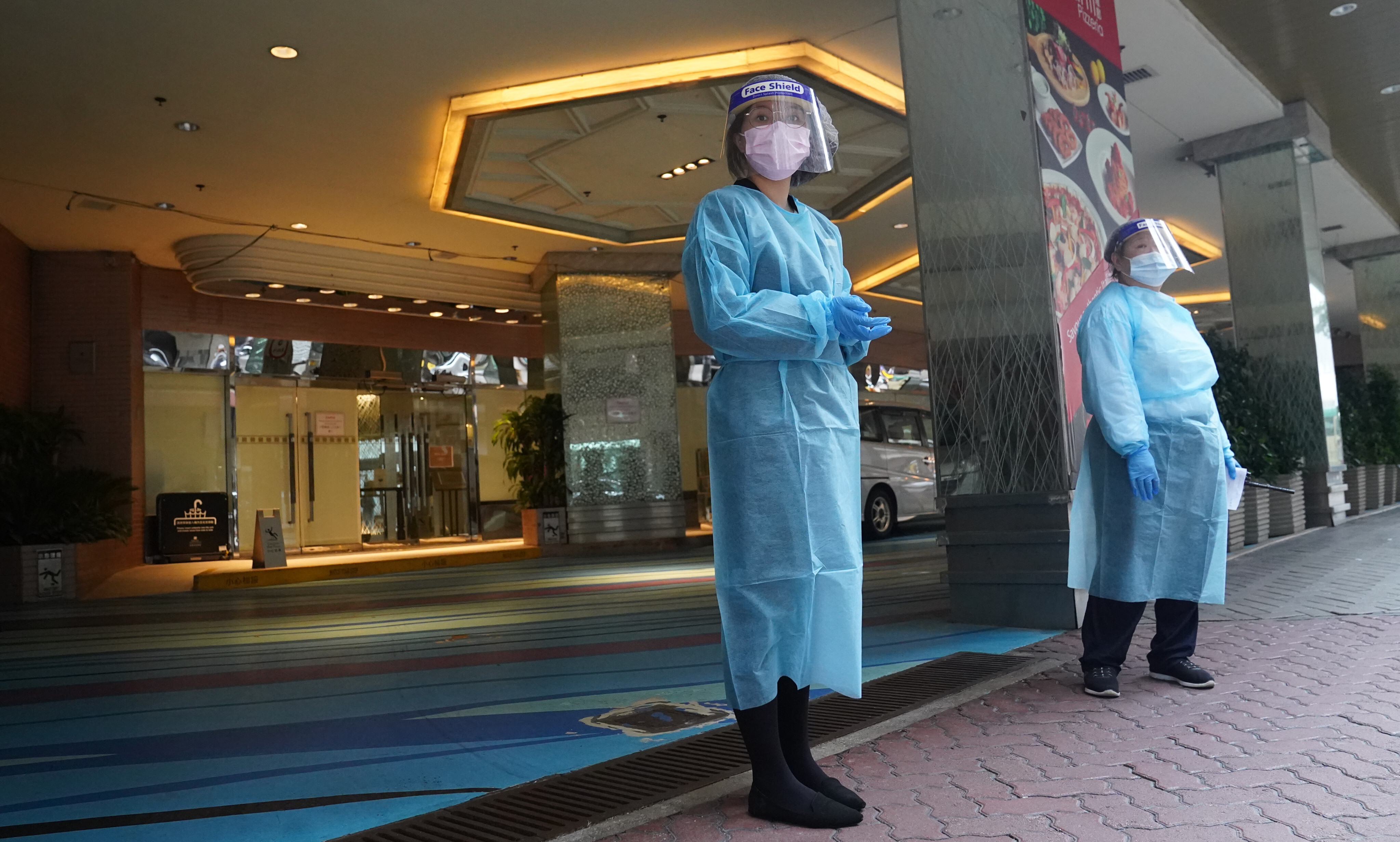 Health care staff outside the Regal Oriental Hotel in Kowloon City, a designated quarantine facility. Photo: Sam Tsang