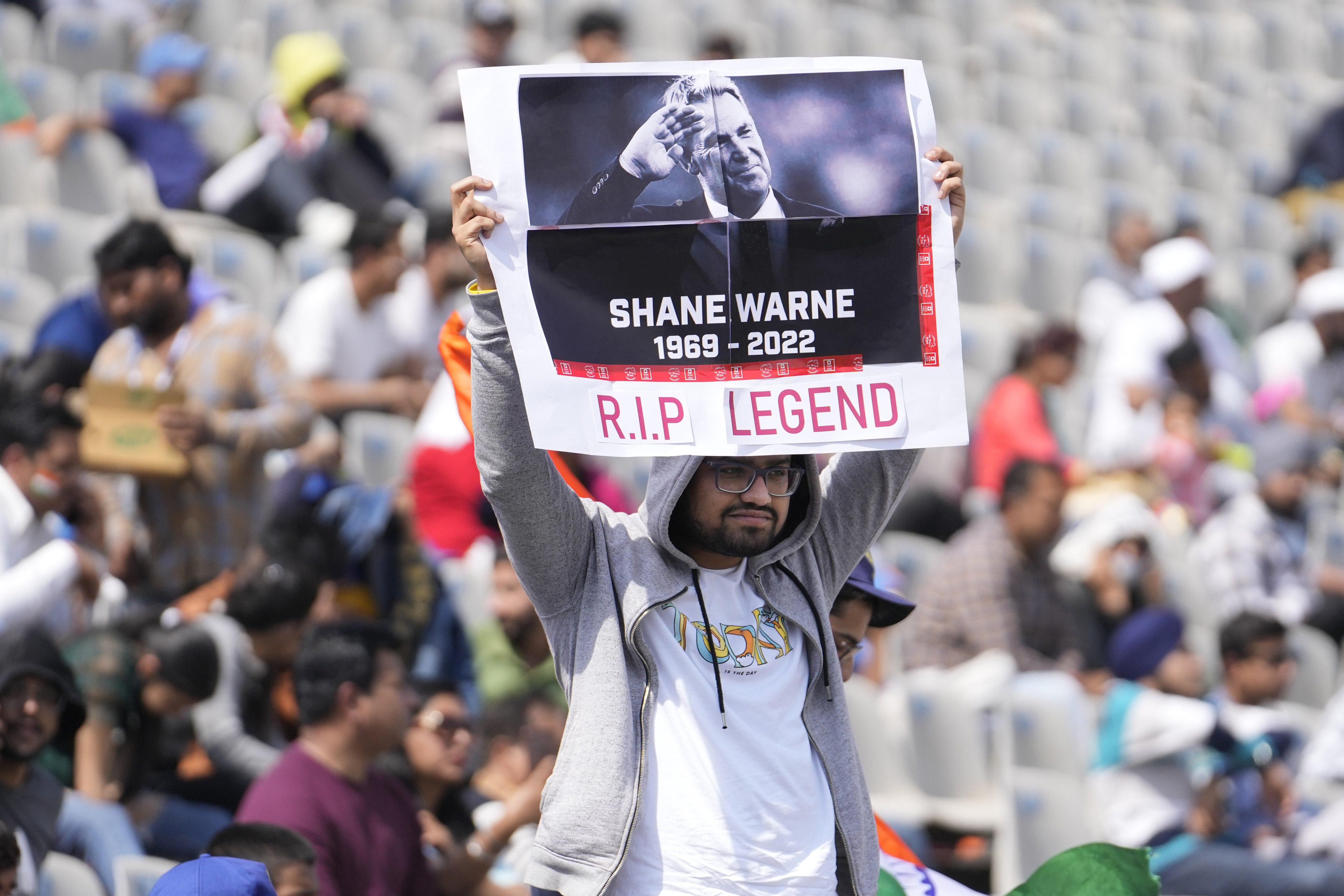 A cricket fan holds up a placard to pay tribute to Australian cricketer Shane Warne, in Mohali, India. Photo: AP