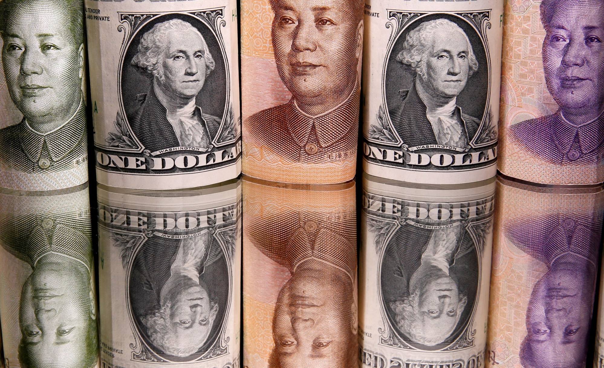 Yuan chinês e notas de dólar americano. Foto: Reuters