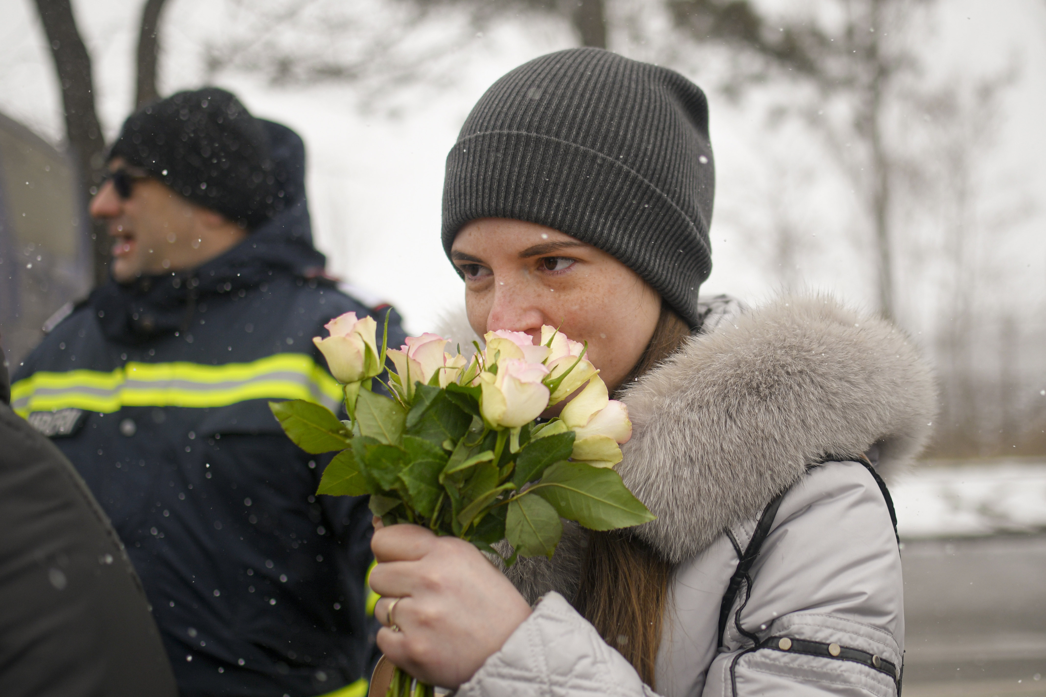 A refugee fleeing the conflict in Ukraine smells a bouquet of roses on International Women’s Day, at the Romanian-Ukrainian border, in Siret, Romania, on Tuesday. Photo: AP