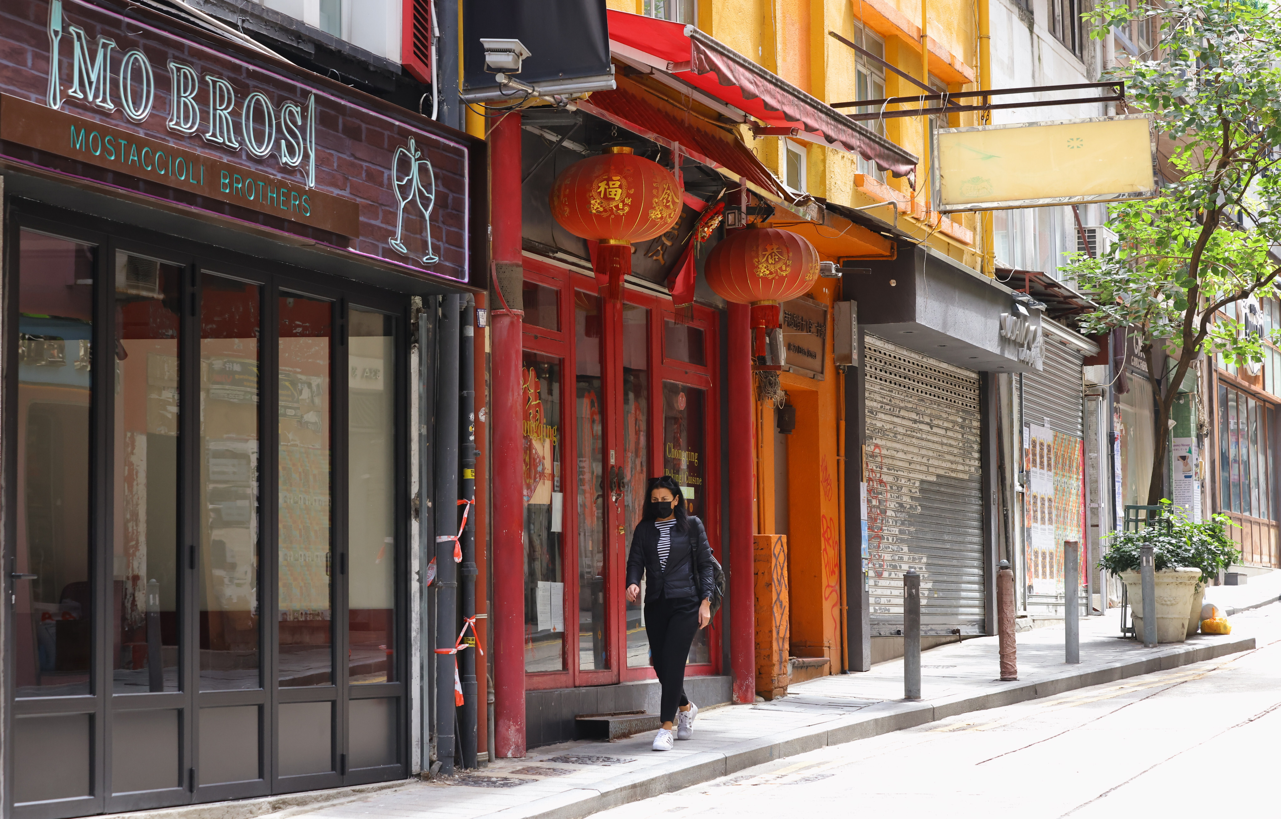 A woman walks down a deserted street with shuttered shops in SoHo, Hong Kong, on February 28. Photo: Dickson Lee