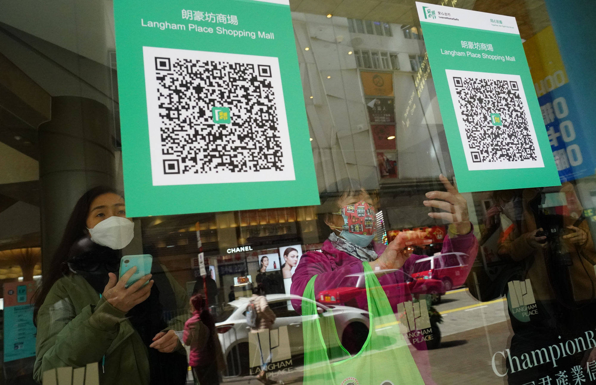 People scan a QR code at a shopping mall in Mong Kok on February 24, the first day of the implementation of the vaccine pass scheme in shopping malls, restaurants and supermarkets.  Photo: Felix Wong