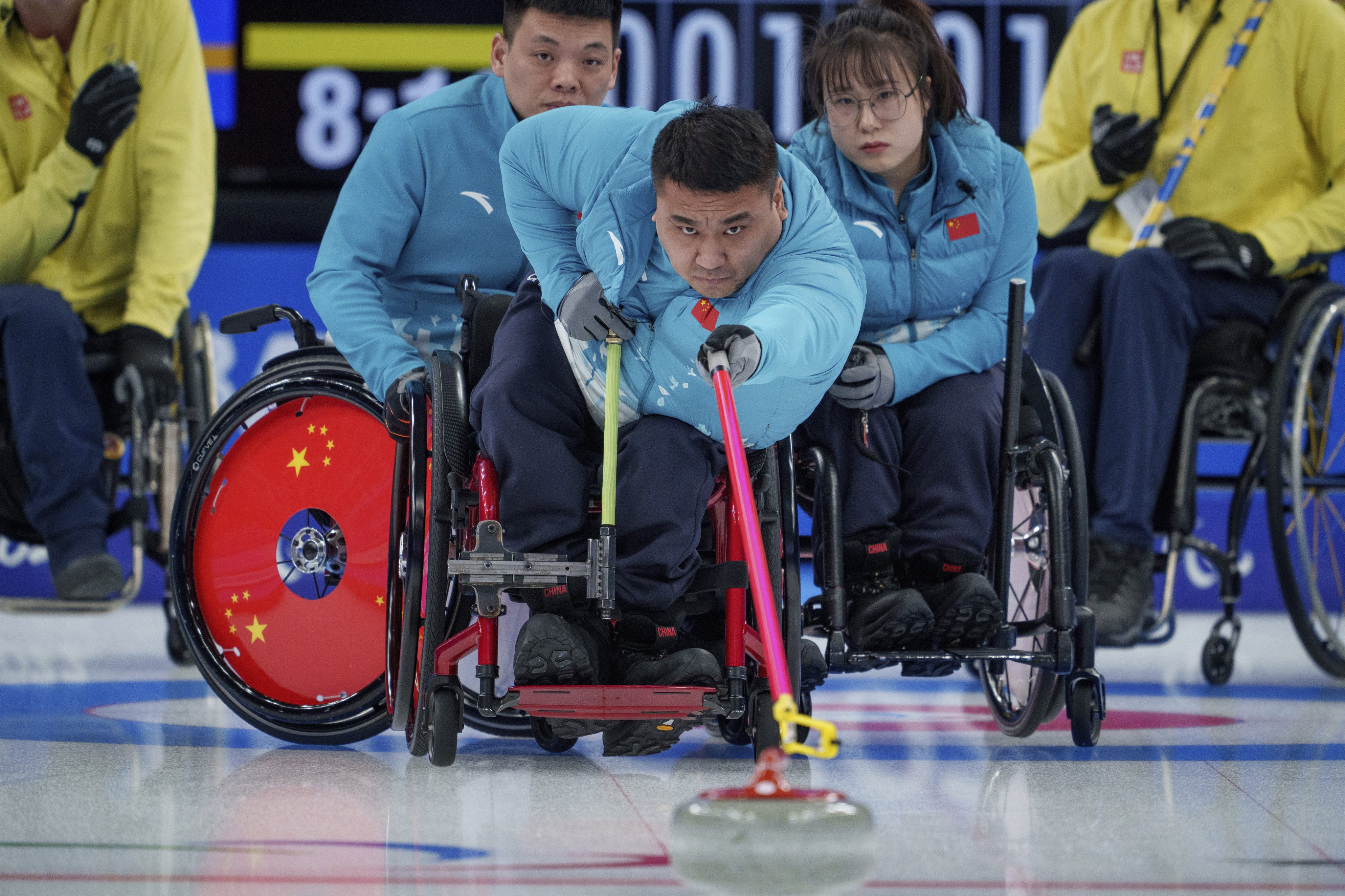 Wang Haitao of China plays a stone in the wheelchair curling gold medal game against Sweden. Photo: AP