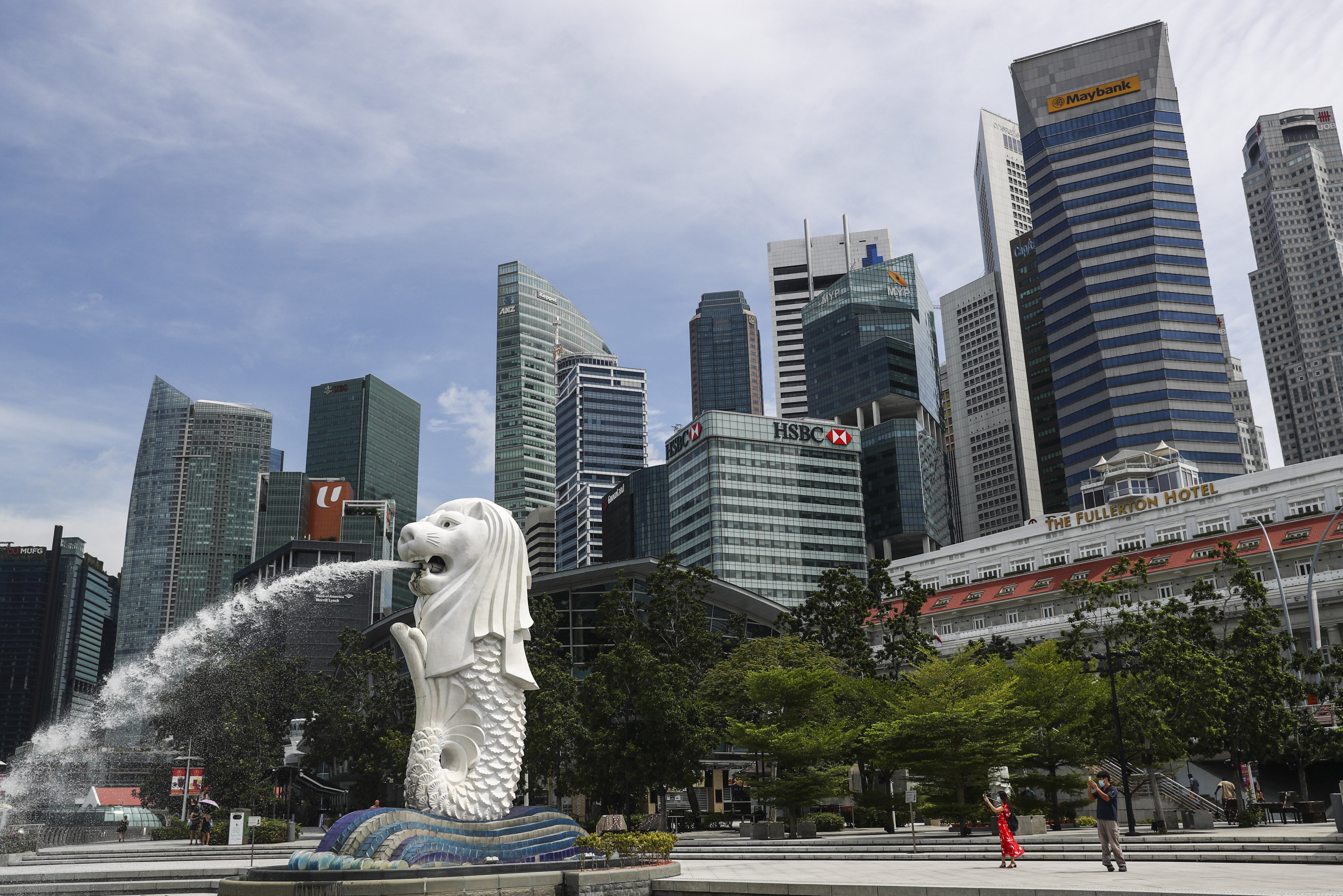 The financial skyline of Singapore is seen behind the Merlion statue in Marina Bay. Photo: AP.