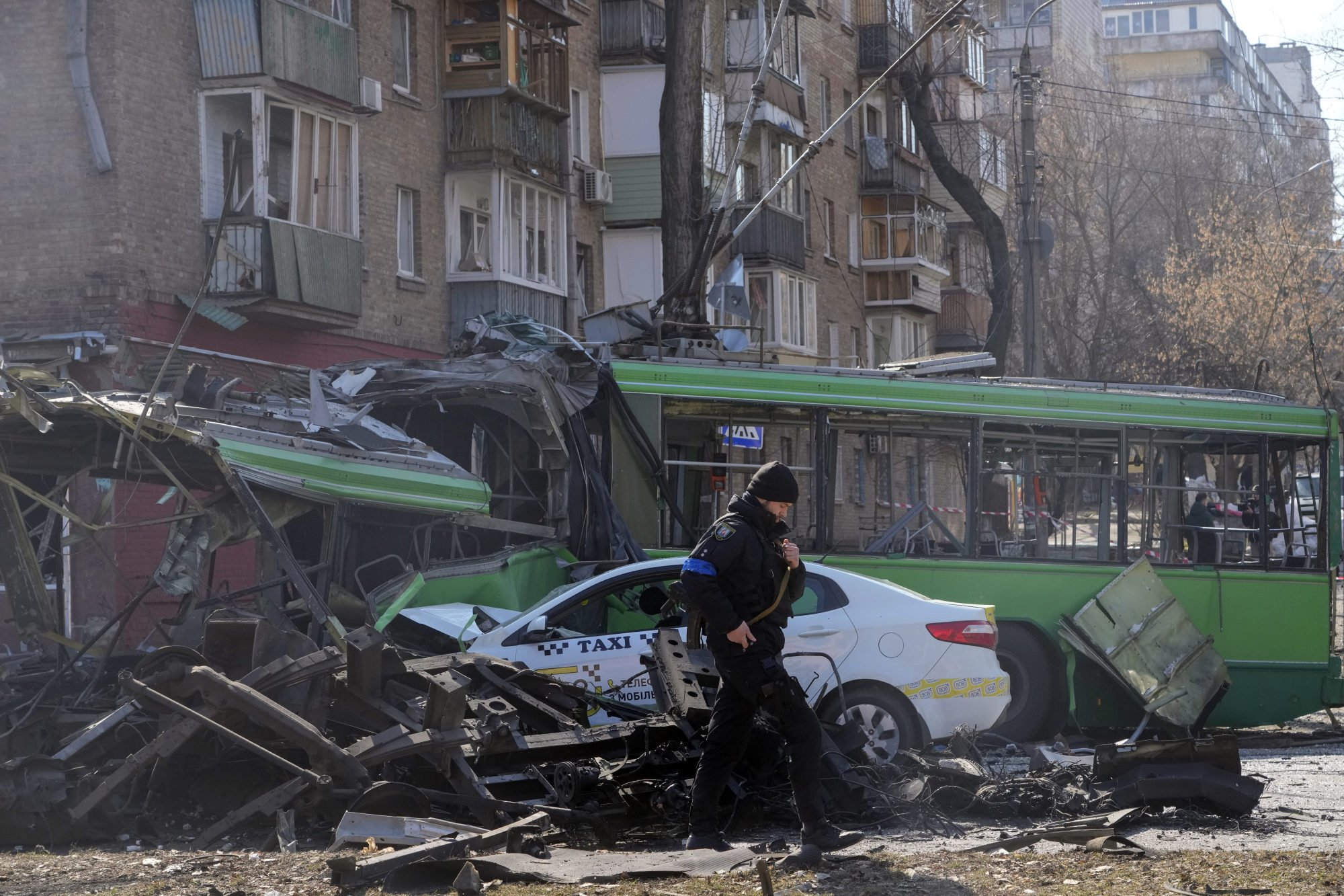 A Ukrainian soldier walks past a destroyed trolley and taxi after a Russian bombing attack in Kyiv on Monday. Photo: AP