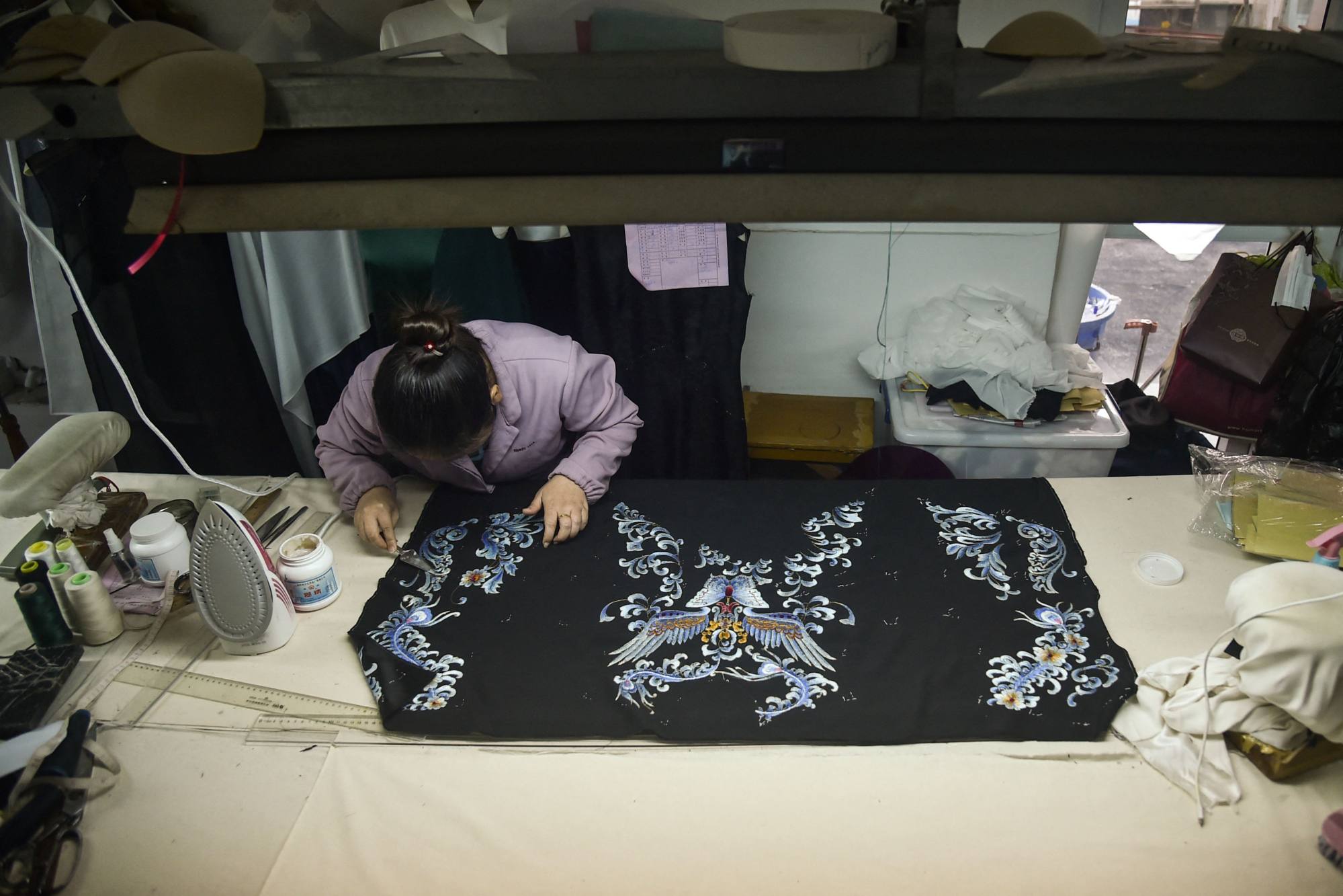 A tailor making a qipao in Shanghai. Photo: AFP