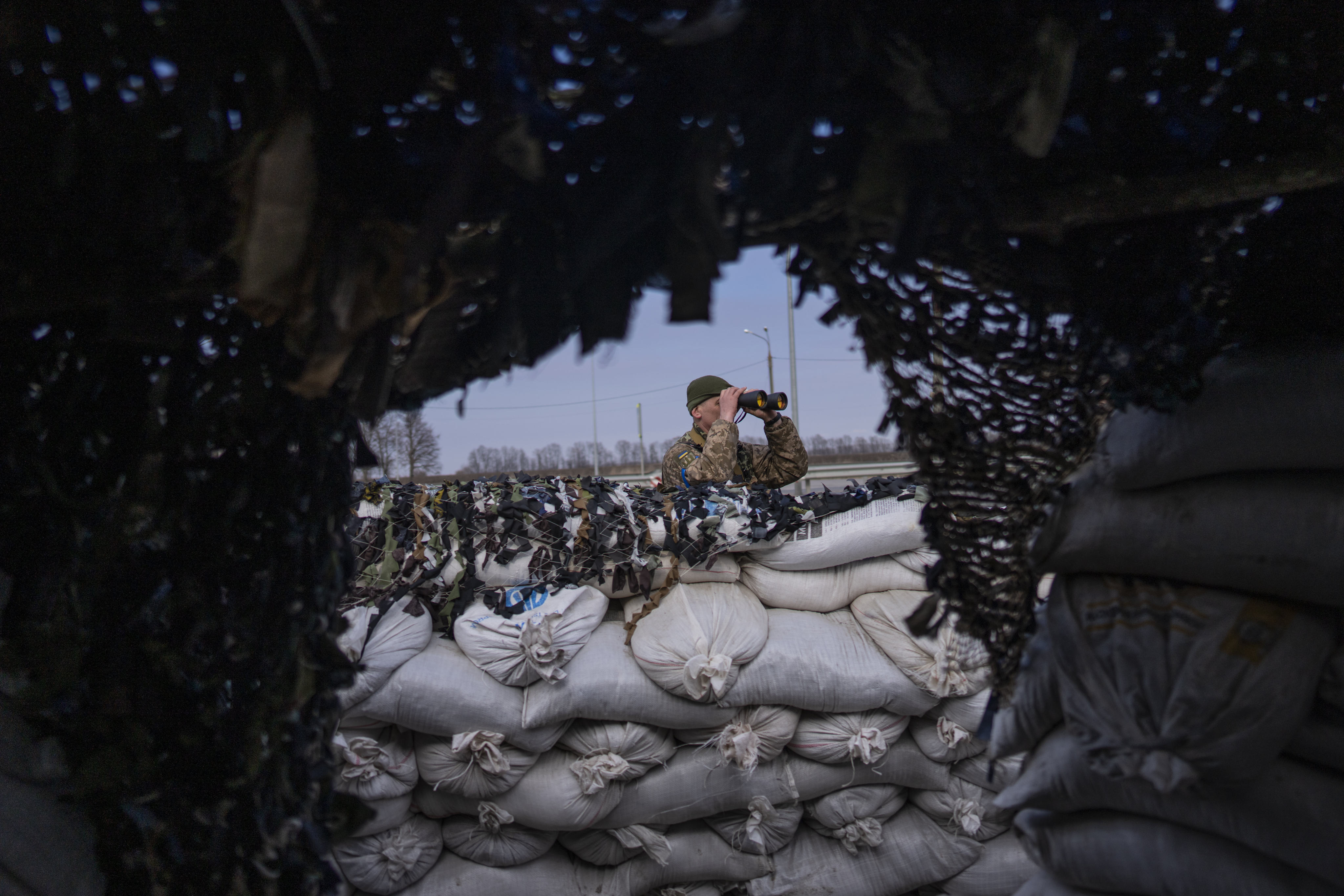 A Ukrainian soldier looks through binoculars at a military check point in Lityn. Photo: AP