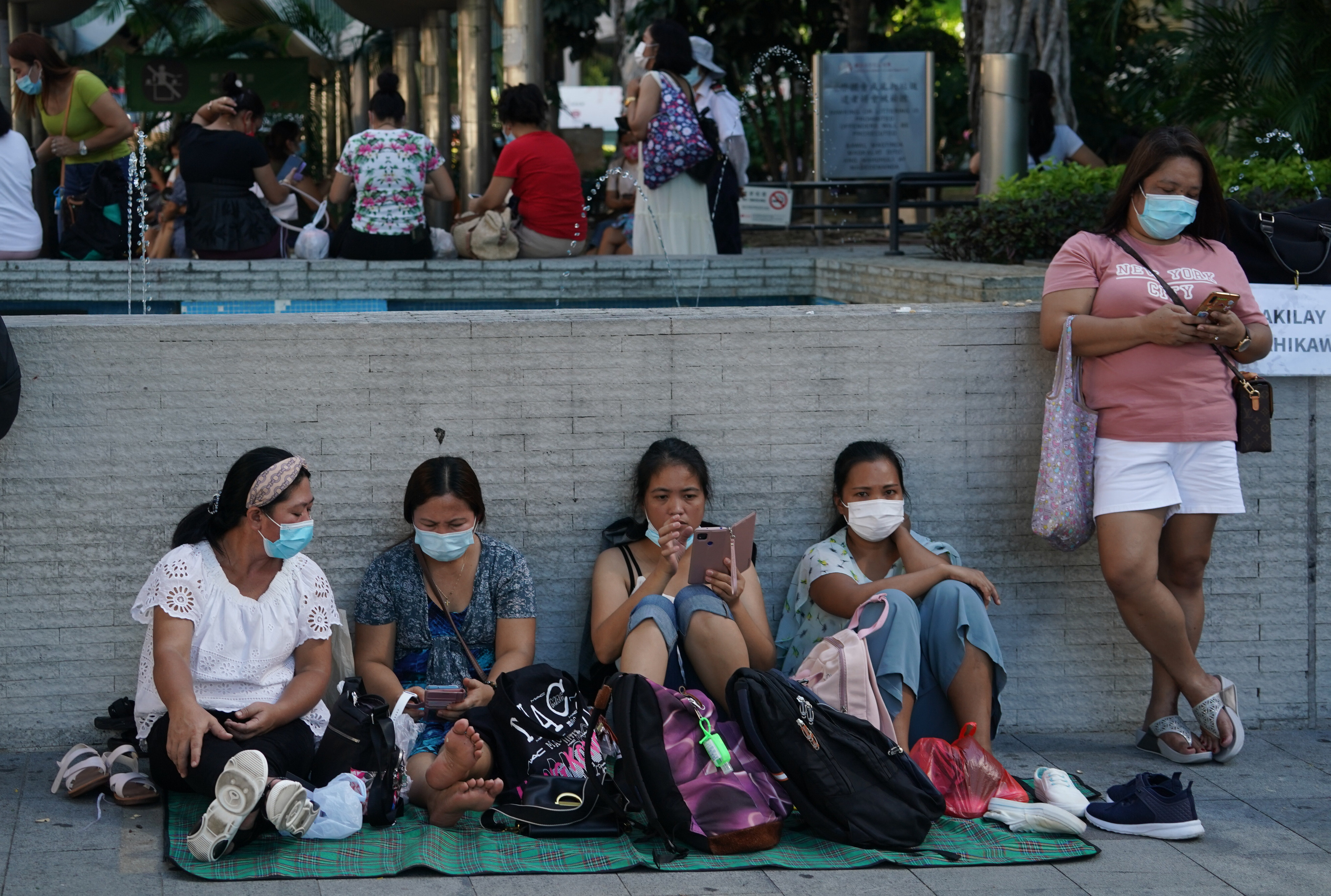 Domestic helpers relax outdoors on a day off. Hong Kong’s 340,000 helpers will miss out on this year’s HK$10,000 consumption voucher handout. Photo: Felix Wong