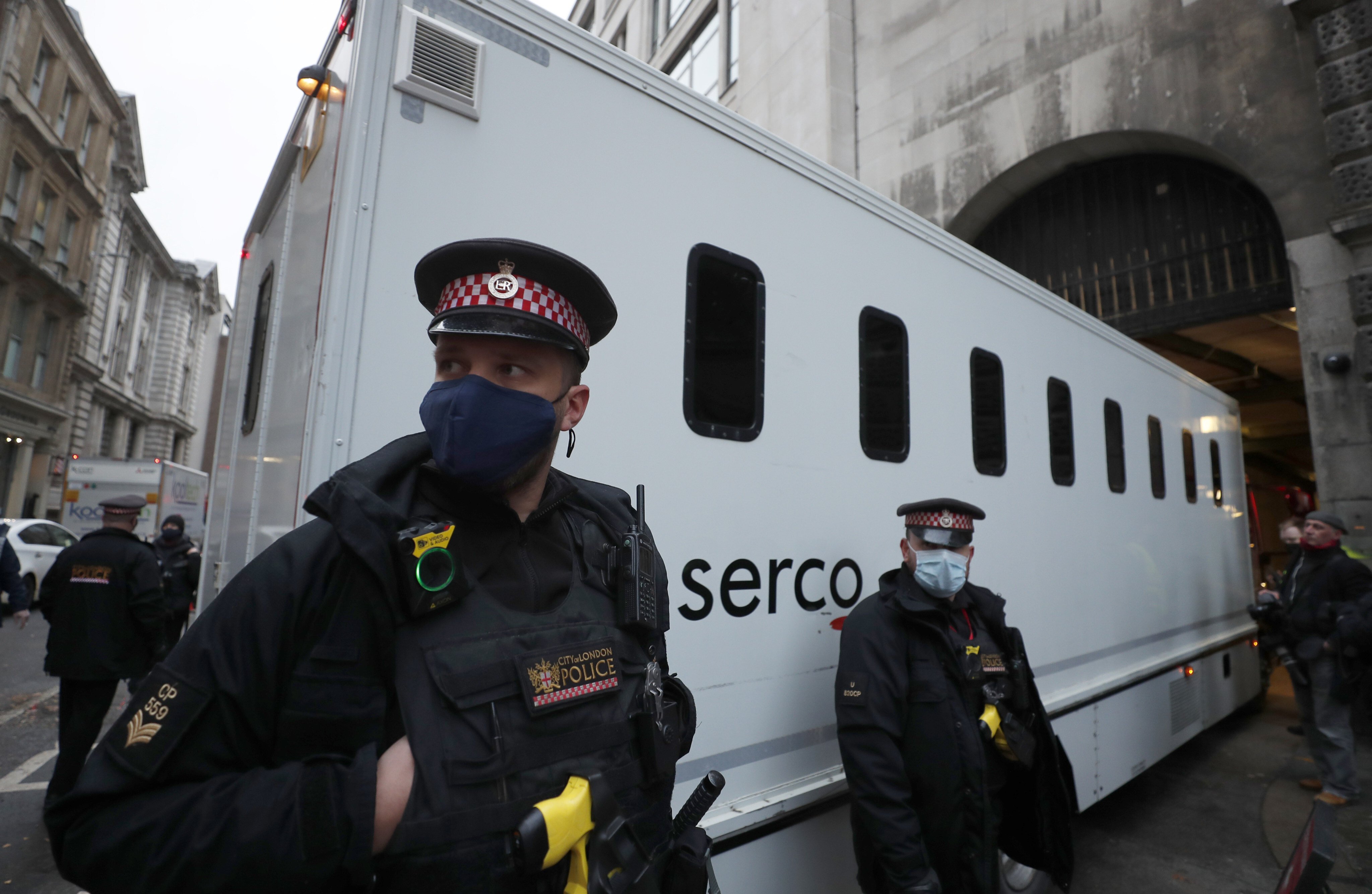 Police guard a prisoner transport van as it arrives at the Old Bailey court in London. Photo: AP