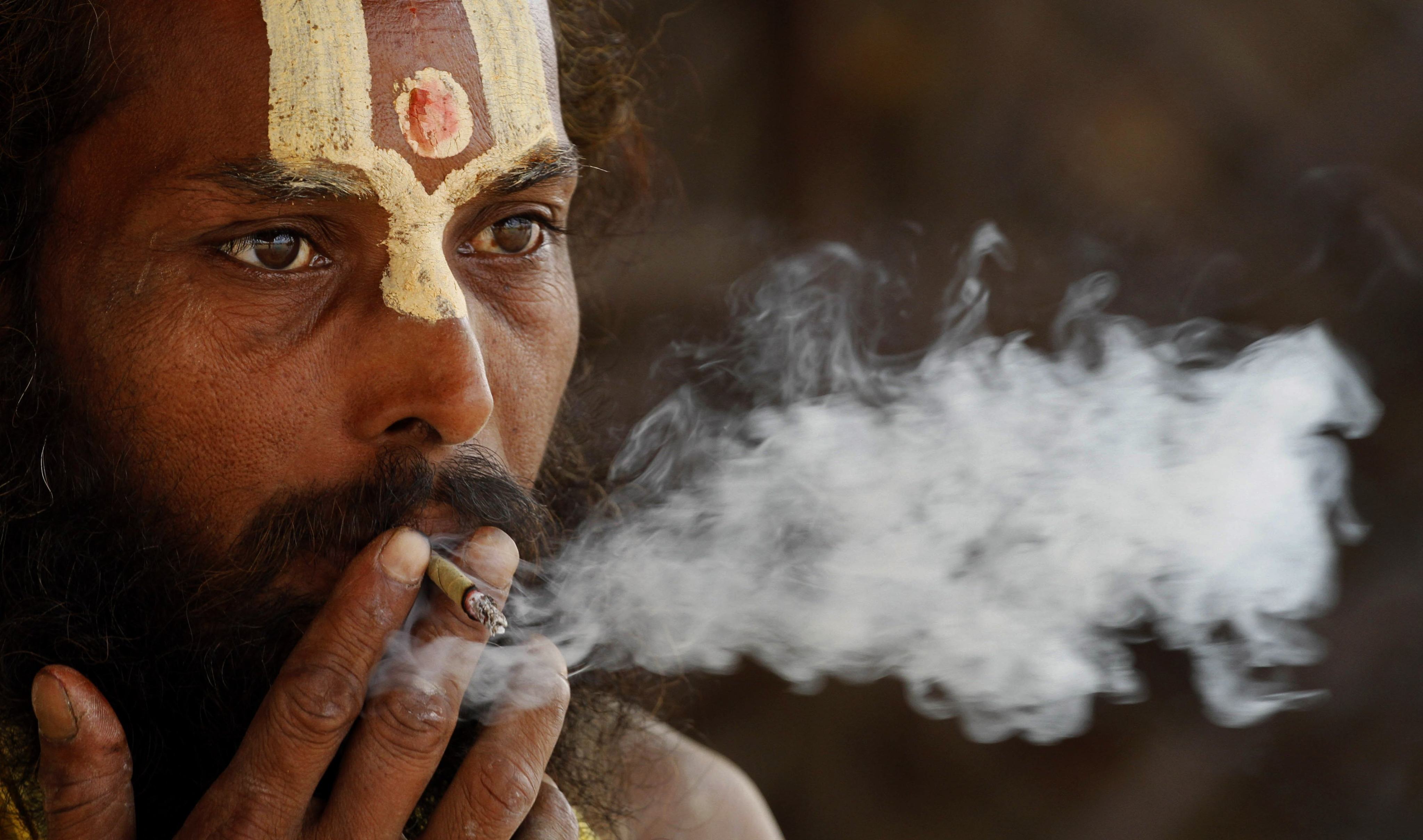 A Hindu holy man smokes ‘bidi’, or a small hand-rolled Indian cigarette, in Allahabad. File photo: AP