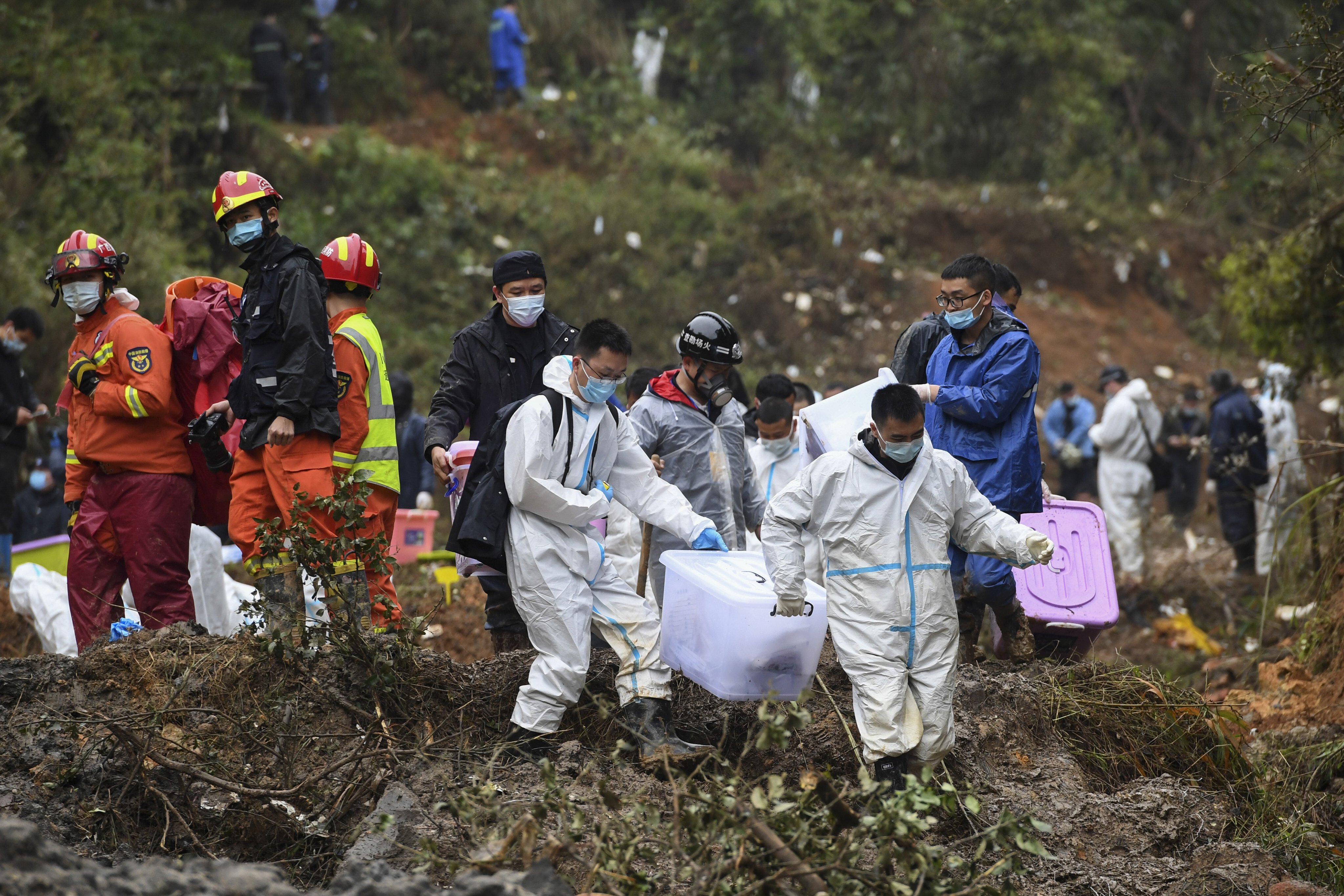 Search and rescue workers carry boxes believed to contain belongings of people on board the crashed China Eastern flight in Teng county in the Guangxi Zhuang autonomous region on Thursday. Photo: Xinhua via AP