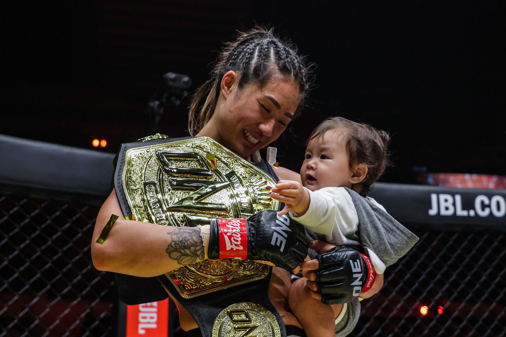 Angela Lee celebrates with her infant daughter after retaining her title at ONE X. Photos: ONE Championship