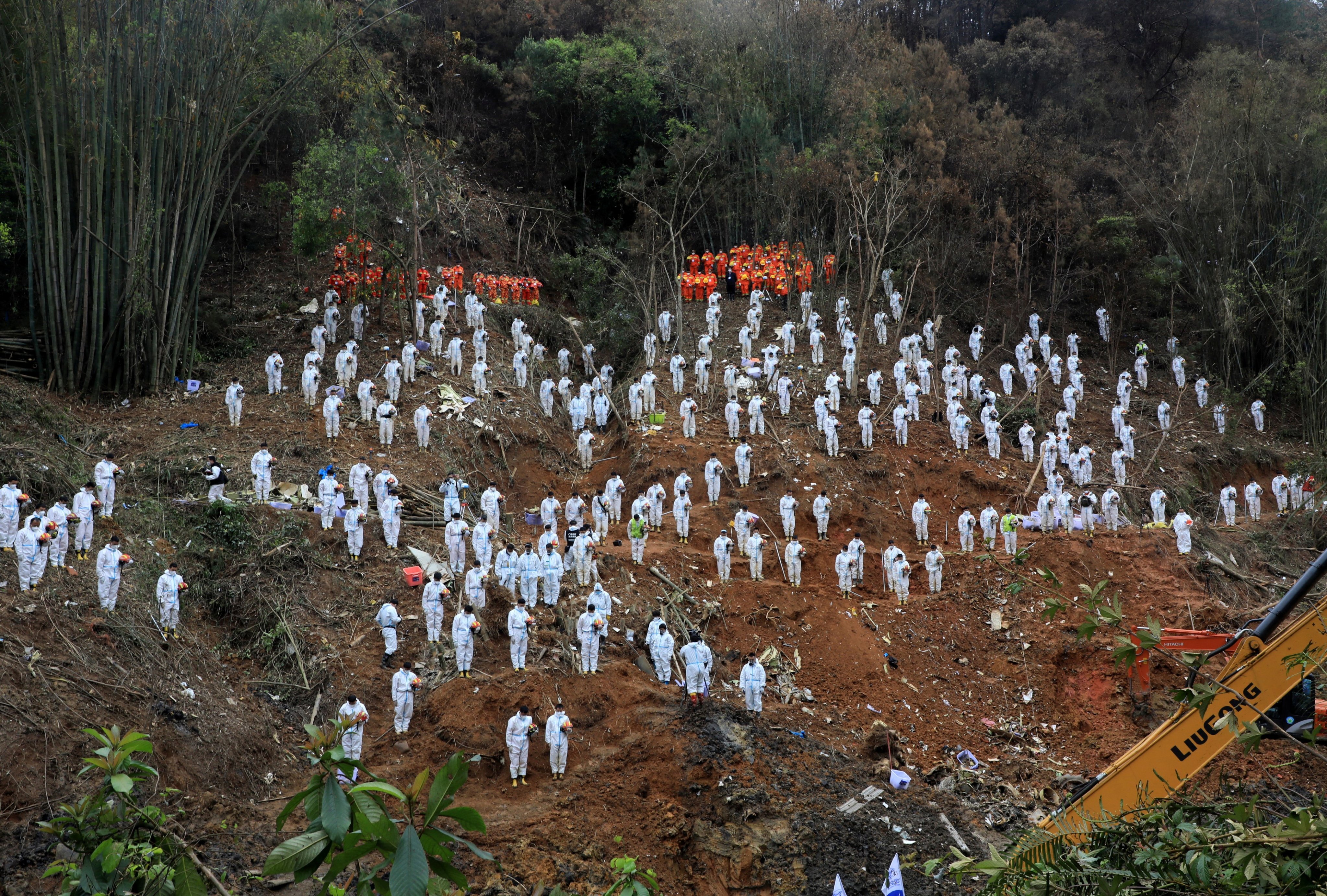 Rescue workers stand in a silent tribute at the crash site in Wuzhou, Guangxi Zhuang autonomous region on Sunday. Photo: Reuters